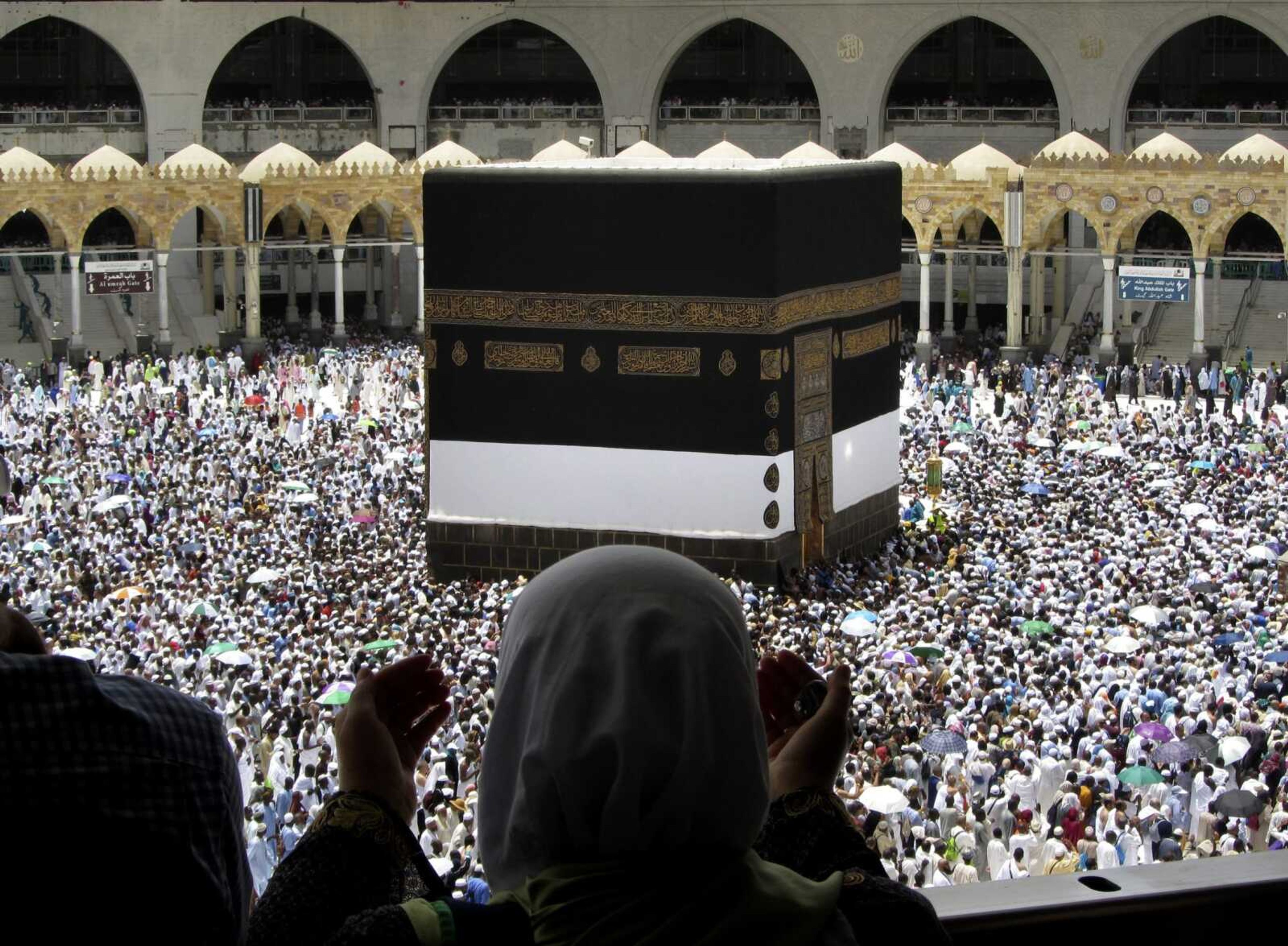 A Muslim pilgrim prays Friday as she watches thousands of pilgrims circle the Kaaba, the cubic building at the Grand Mosque ahead of the Hajj pilgrimage in the Muslim holy city of Mecca, Saudi Arabia. Hundreds of thousands of Muslims have arrived in the kingdom to participate in the annual hajj pilgrimage, a ritual required of all able-bodied Muslims at least once in their life.