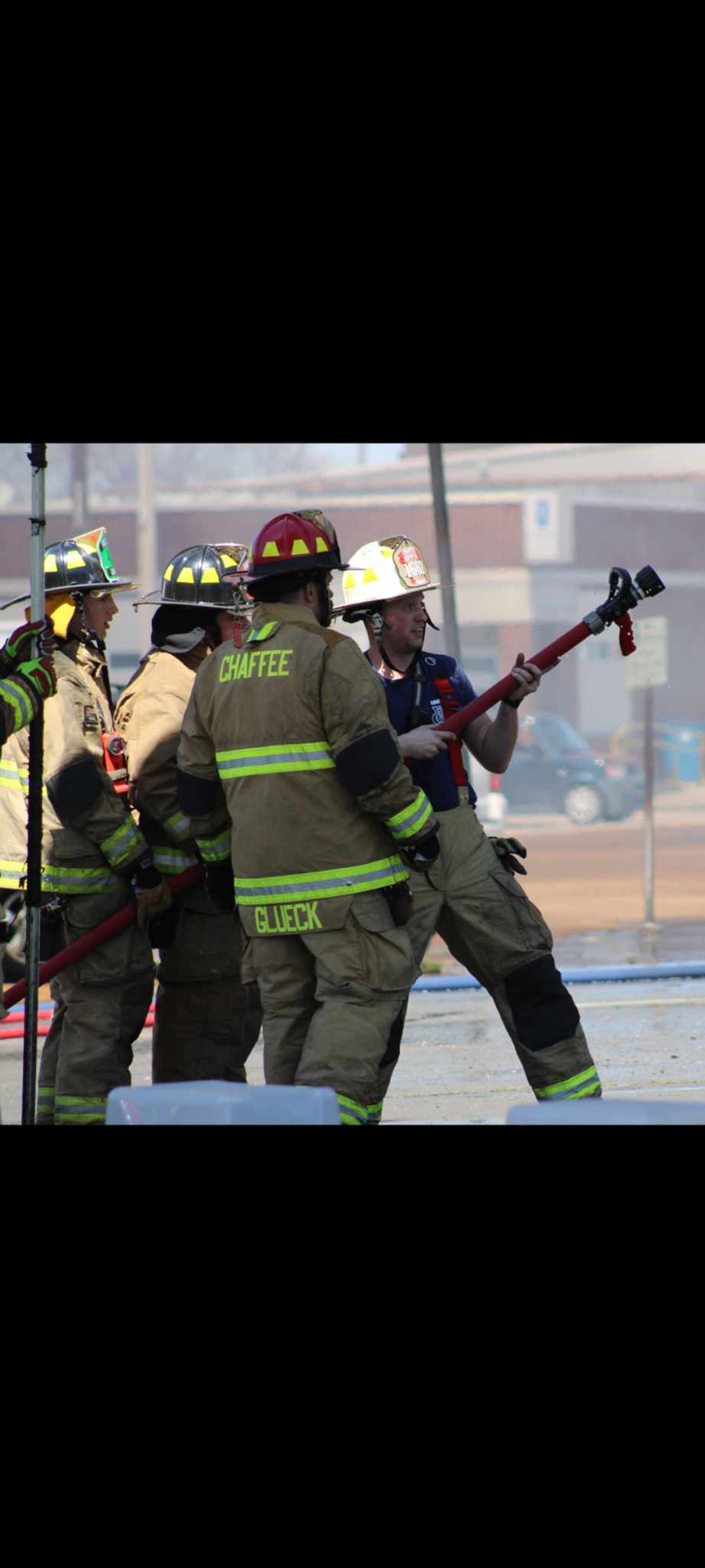 Cody Johnson shows younger volunteers how to use a hose on a fire.