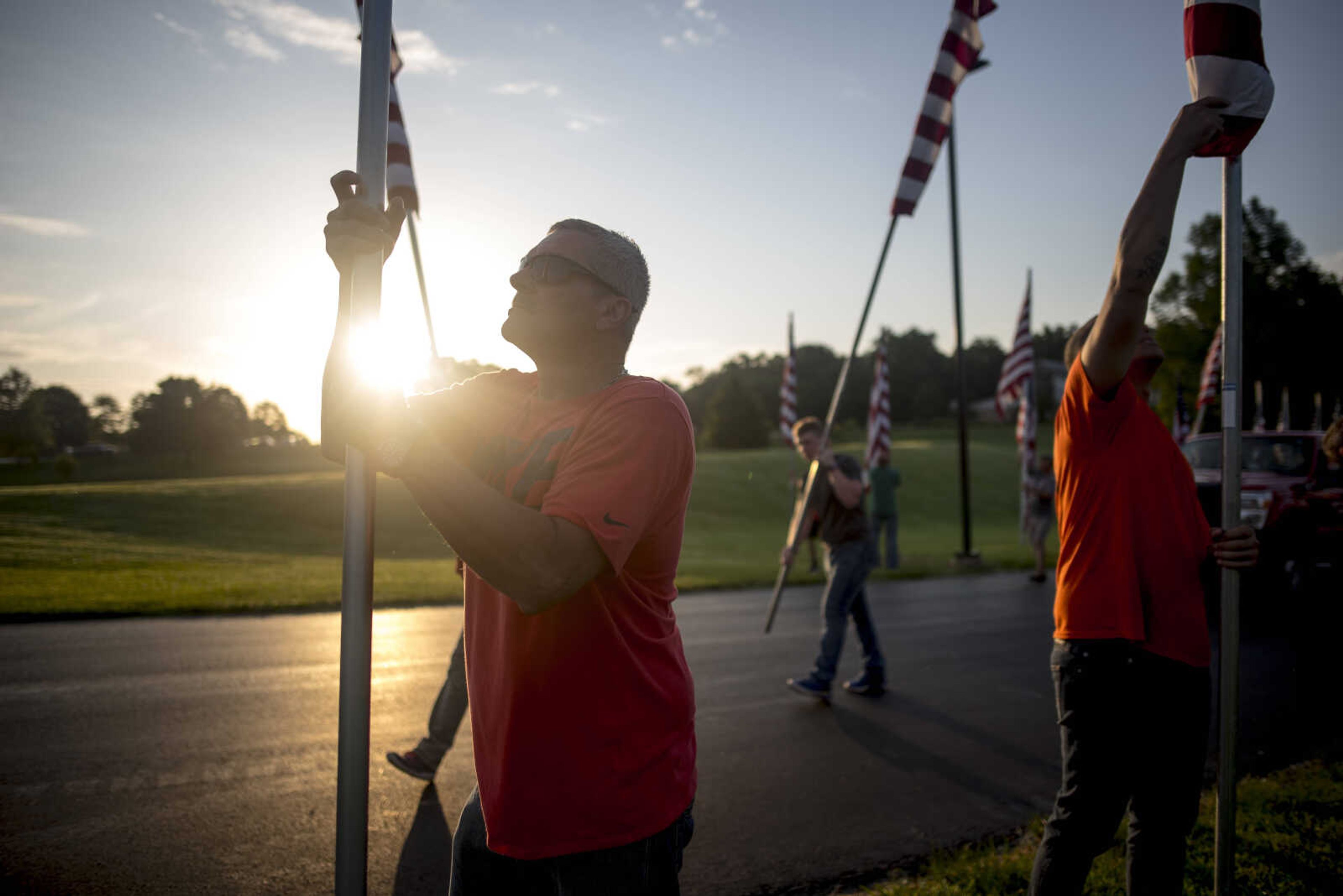 Scott Marvel, left, installs a flag Wednesday, July 3, 2019, Avenue of Flags in Cape Girardeau County Park.