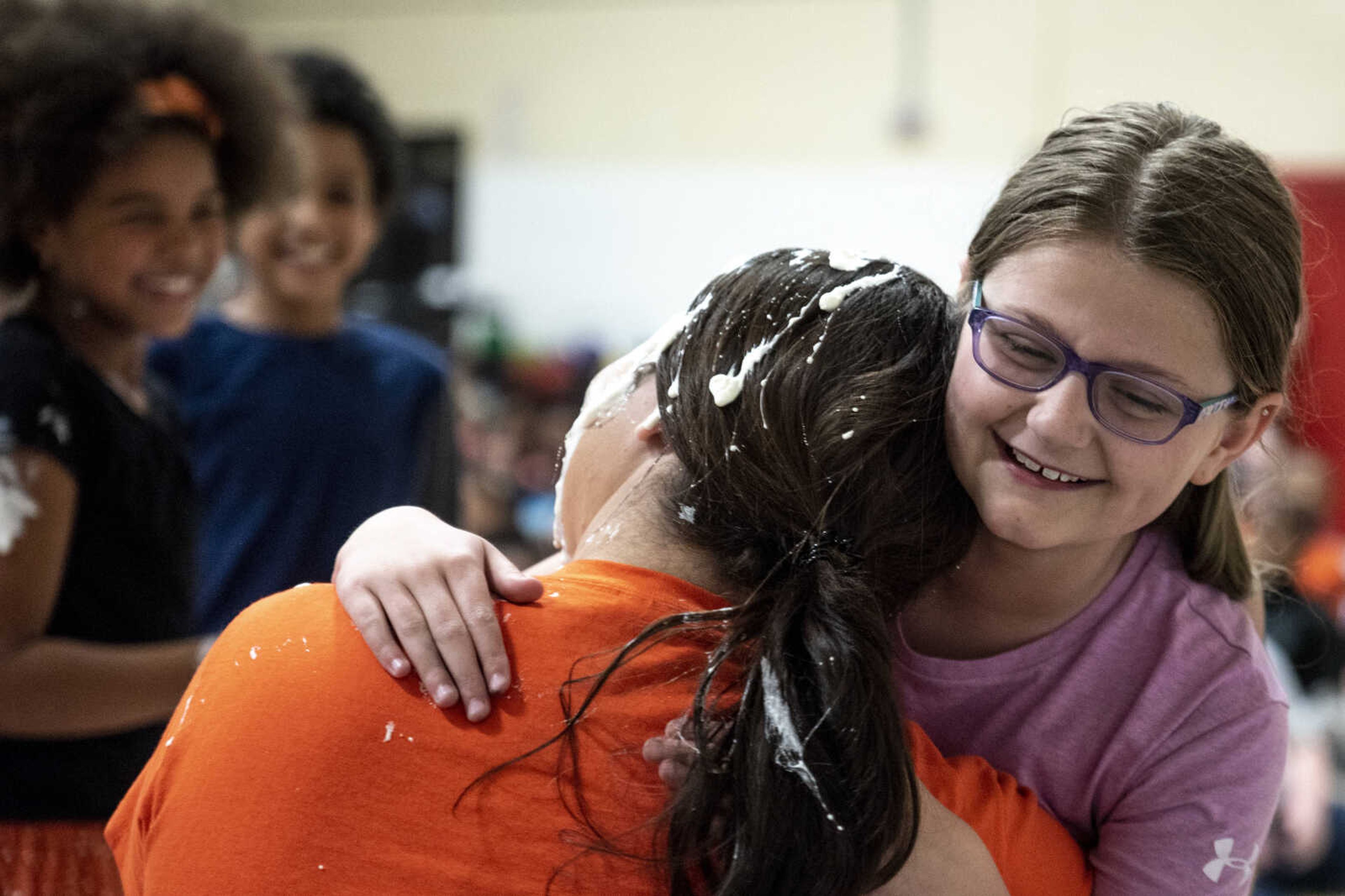 Fourth grader Makayla Brockmire hugs Samantha Rose after pieing her in the face at Clippard Elementary School Friday, April 5, 2019, in Cape Girardeau. Students earned votes for which teacher(s) would get pied in the face when they brought in donations to raise money for their end-of-the-year play day that is free to students. Through students and other donations, the school raised $550 towards their play day activities.