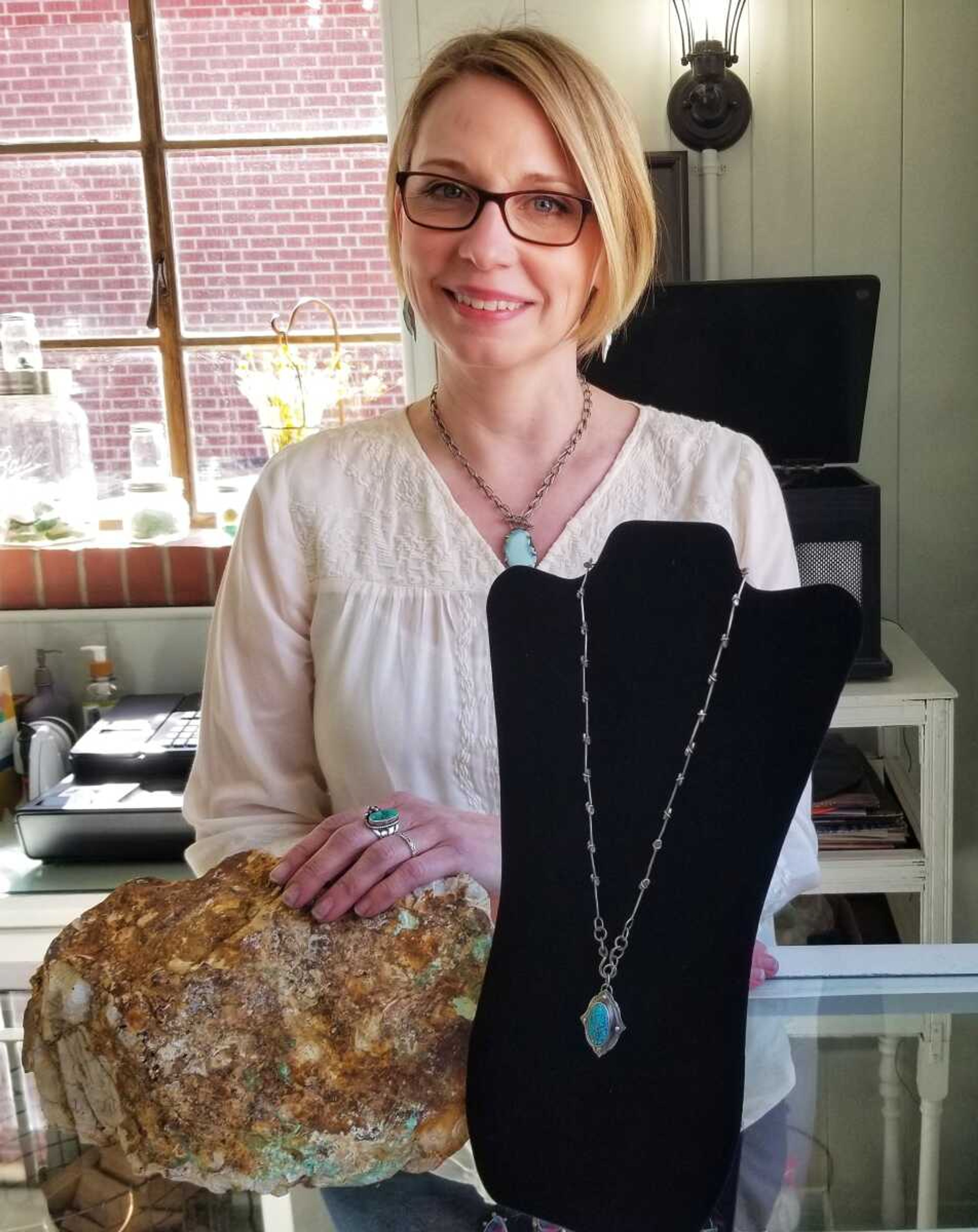 Emily Fulenwider Fox of Jackson's Foxy Lady Stuff poses with a turquoise necklace she handmade, along with a turquoise stone.