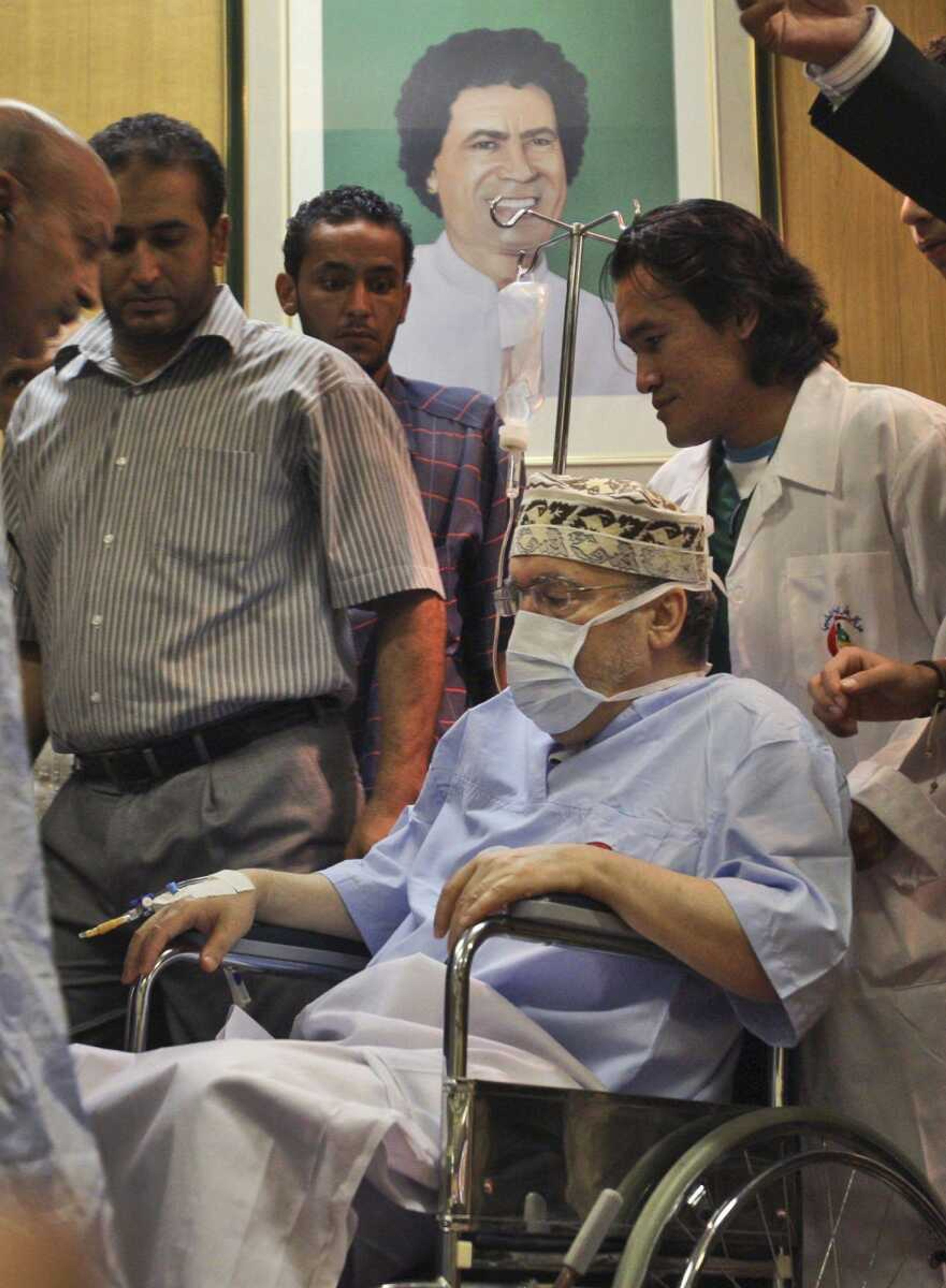 Libyan Abdel Baset al-Megrahi, who was found guilty of the 1988 Lockerbie bombing, is seen Sept. 9 below a portrait of Libyan leader Moammar Gadhafi at the Tripoli international hospital in Tripoli, Libya. (Associated Press)