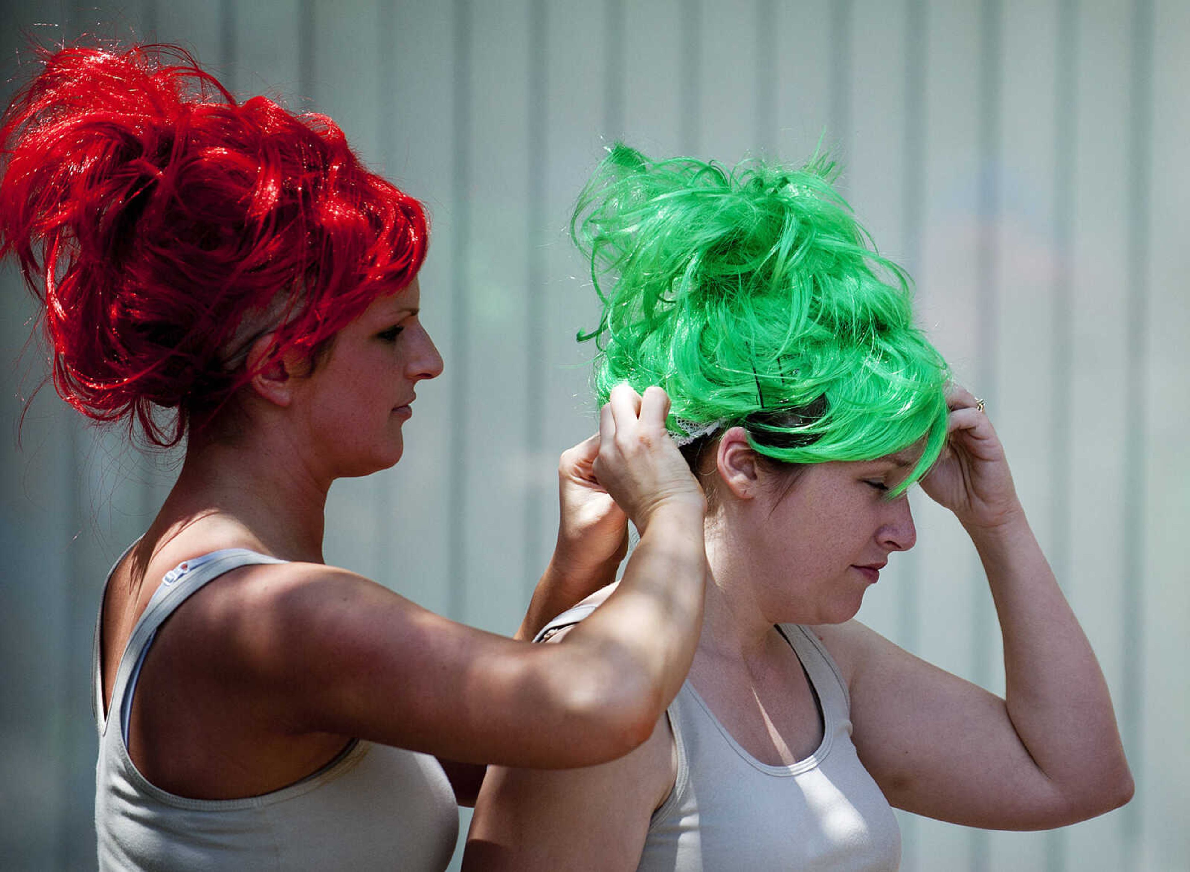 Erin Fields, left, helps Sara Best with her wig before they compete in the Perryville Mayfest Bed Races Saturday, May 10, in Perryville, Mo. They and their team dressed as "Treasure Trolls," for the event.