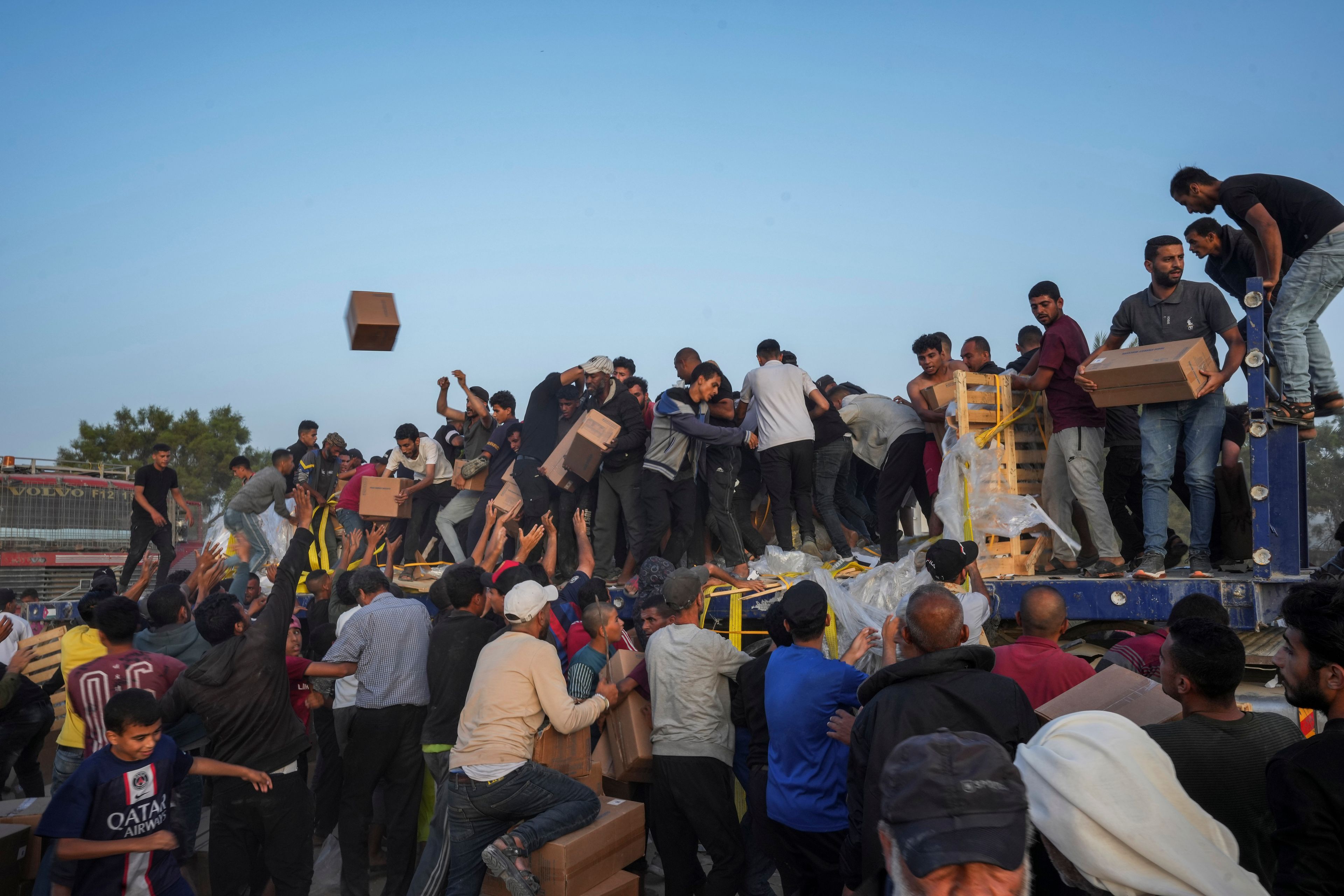 FILE - Palestinians are storming trucks loaded with humanitarian aid brought in through a new U.S.-built pier, in the central Gaza Strip, May 18, 2024. (AP Photo/Abdel Kareem Hana, File)