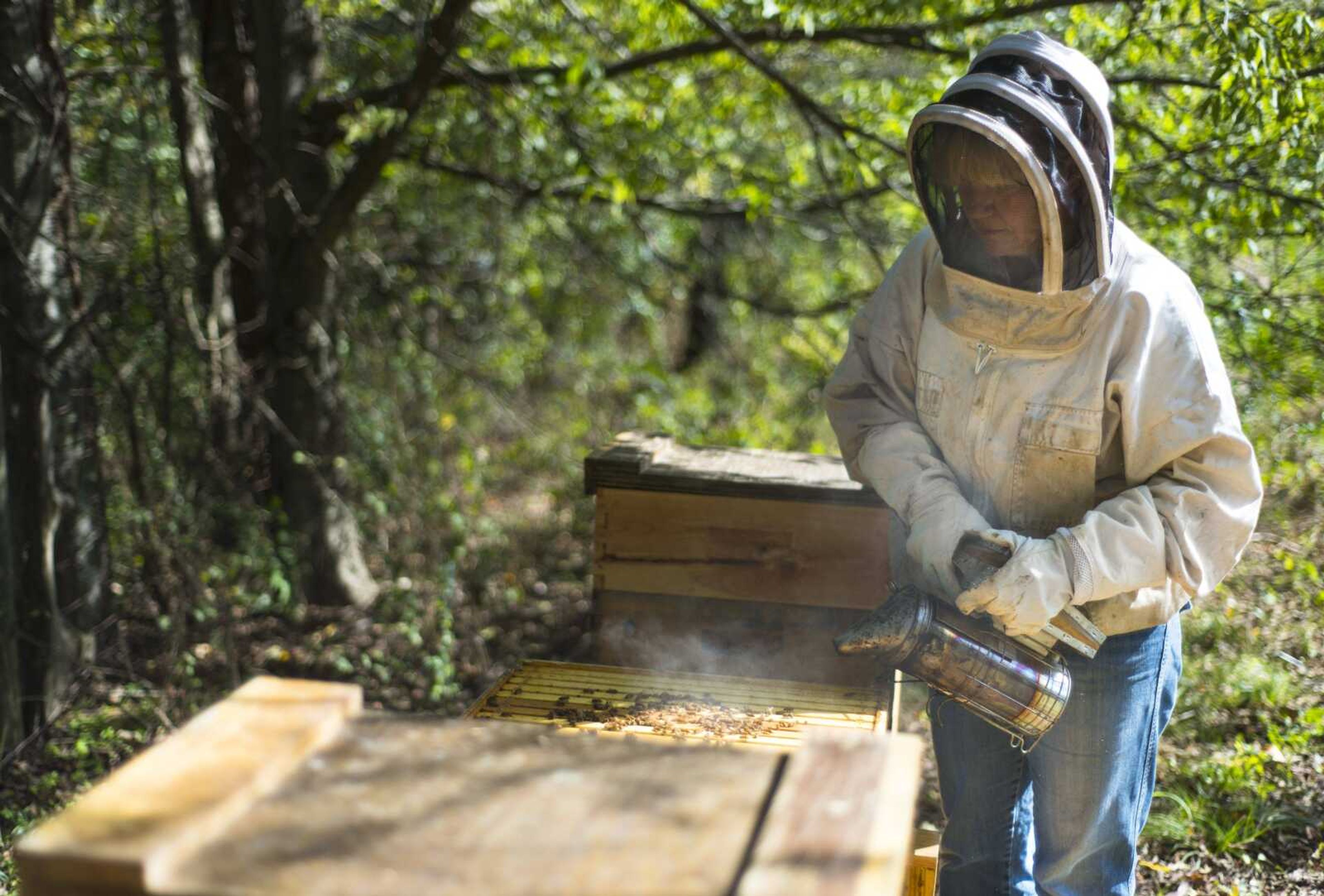 Fashion description:Bottom left and at right: Carmen McNeely tends to her beehives at her home in Jackson.