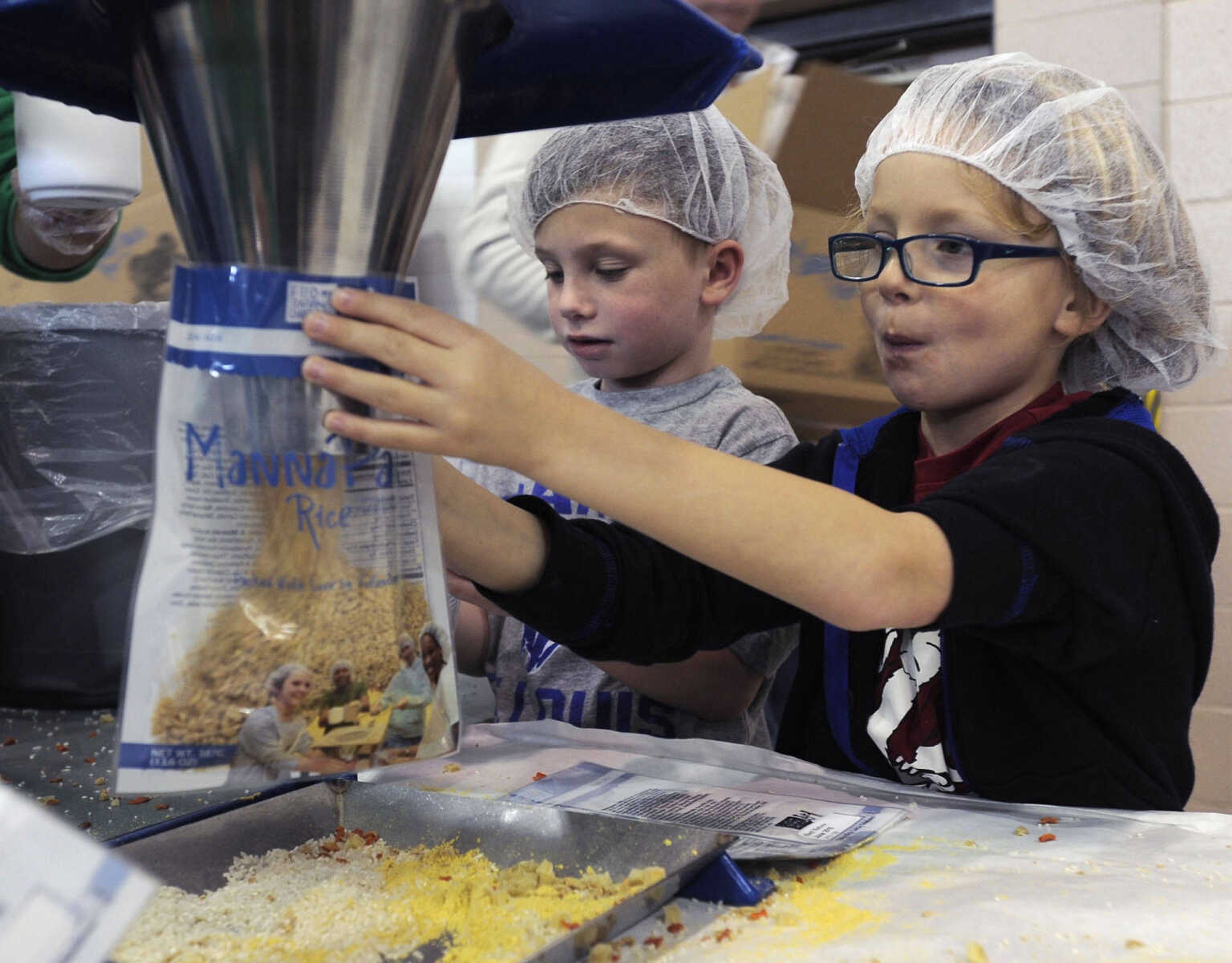 FRED LYNCH ~ flynch@semissourian.com
Spencer Engelhardt, left, and Max Heuring assist with filling MannaPack rice bags at the Feed My Starving Children MobilePack event Sunday, Dec. 7, 2014 at the Osage Centre in Cape Girardeau.