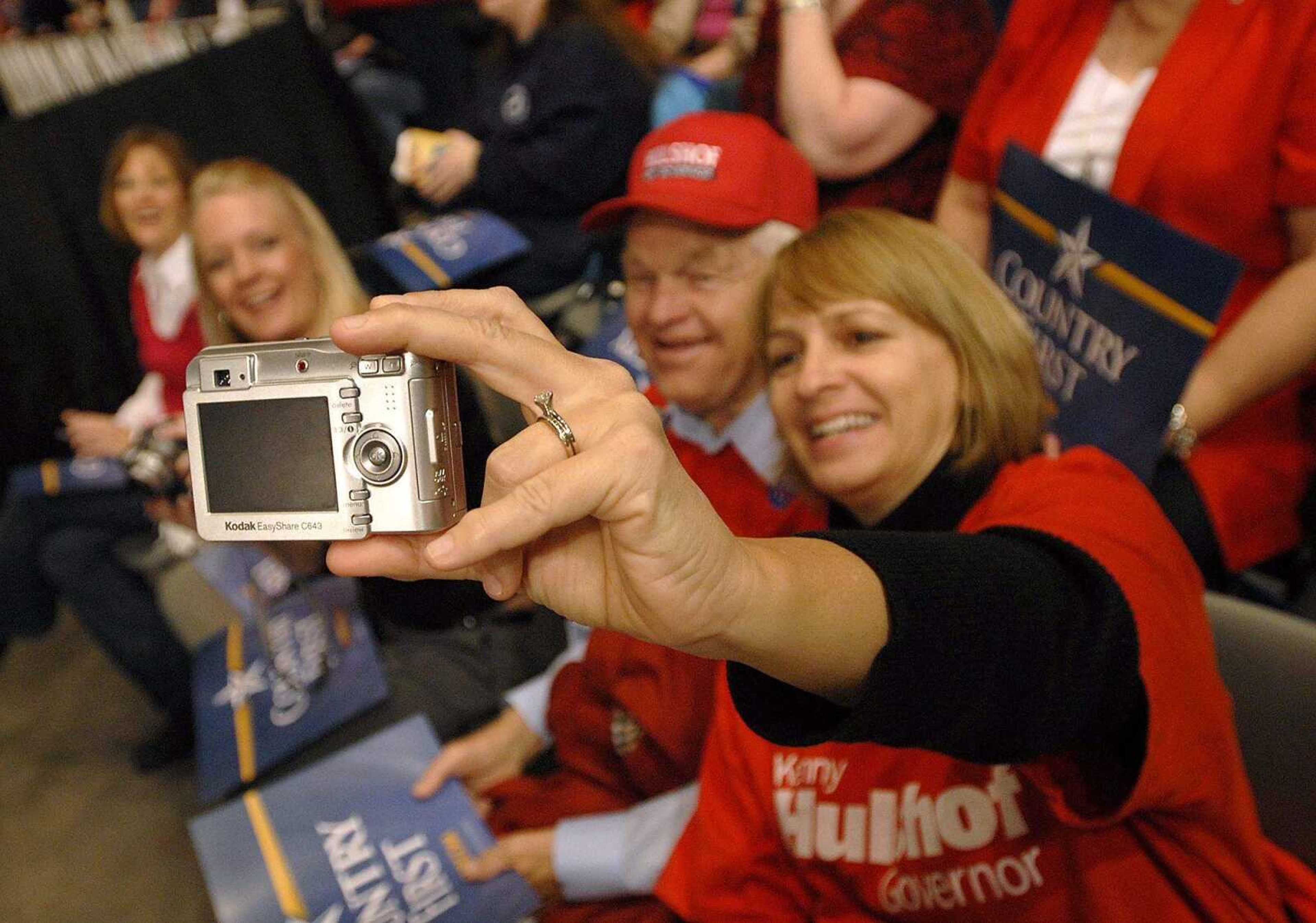 AARON EISENHAUER ~ aeisenhauer@semissourian.com
Janet Haines, a first cousin to gubernatorial candidate Kenny Hulshof, takes a picture of herself and her father Frances Hulshof, Kenny Hulshof's uncle, between speakers.