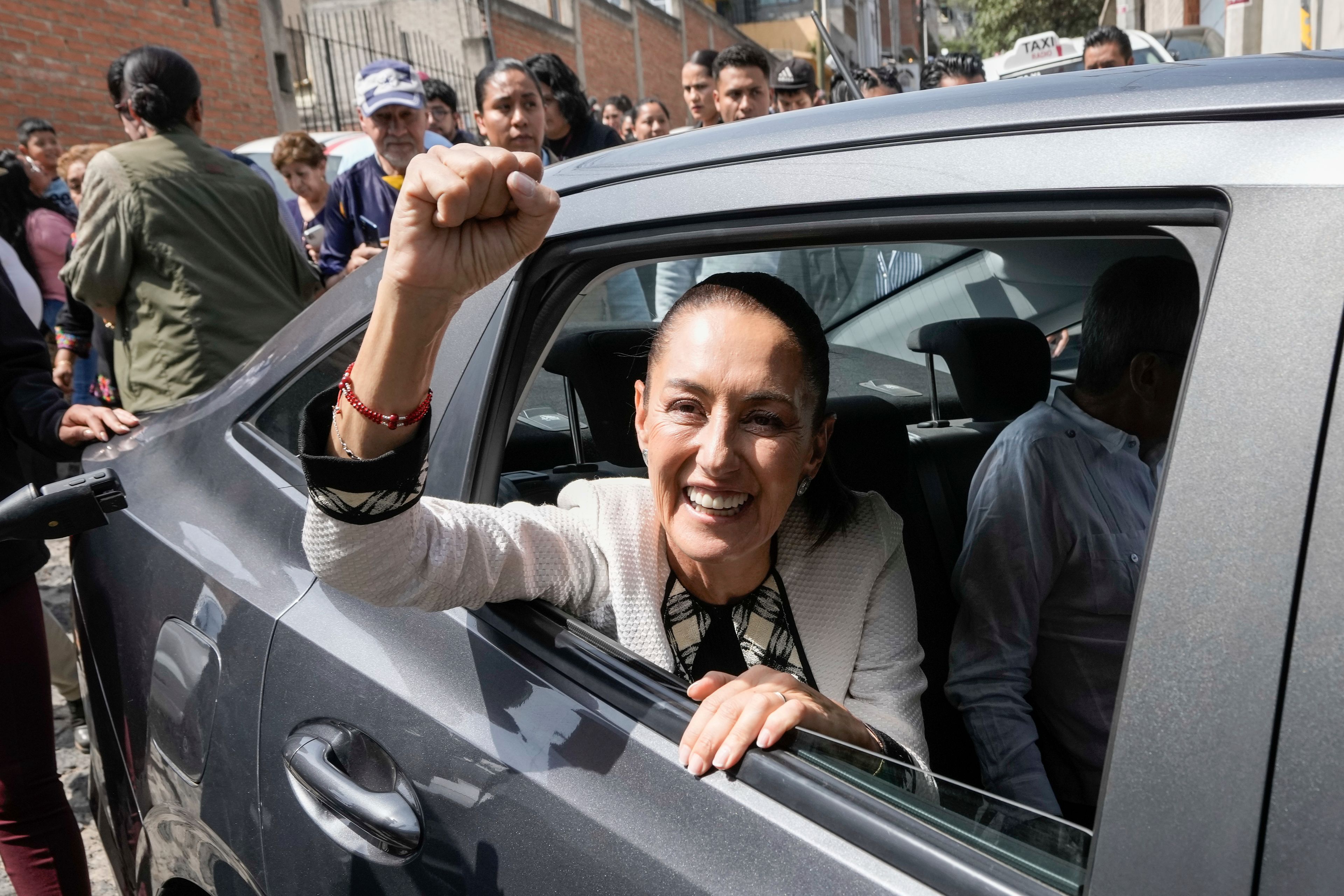 FILE - Claudia Sheinbaum raises a fist as she is driven away from a polling station where she voted in the general elections in Mexico City, June 2, 2024. Sheinbaum, a climate scientist and former Mexico City mayor, will be sworn in as Mexico’s first woman president on Oct. 1. (AP Photo/Eduardo Verdugo, File)