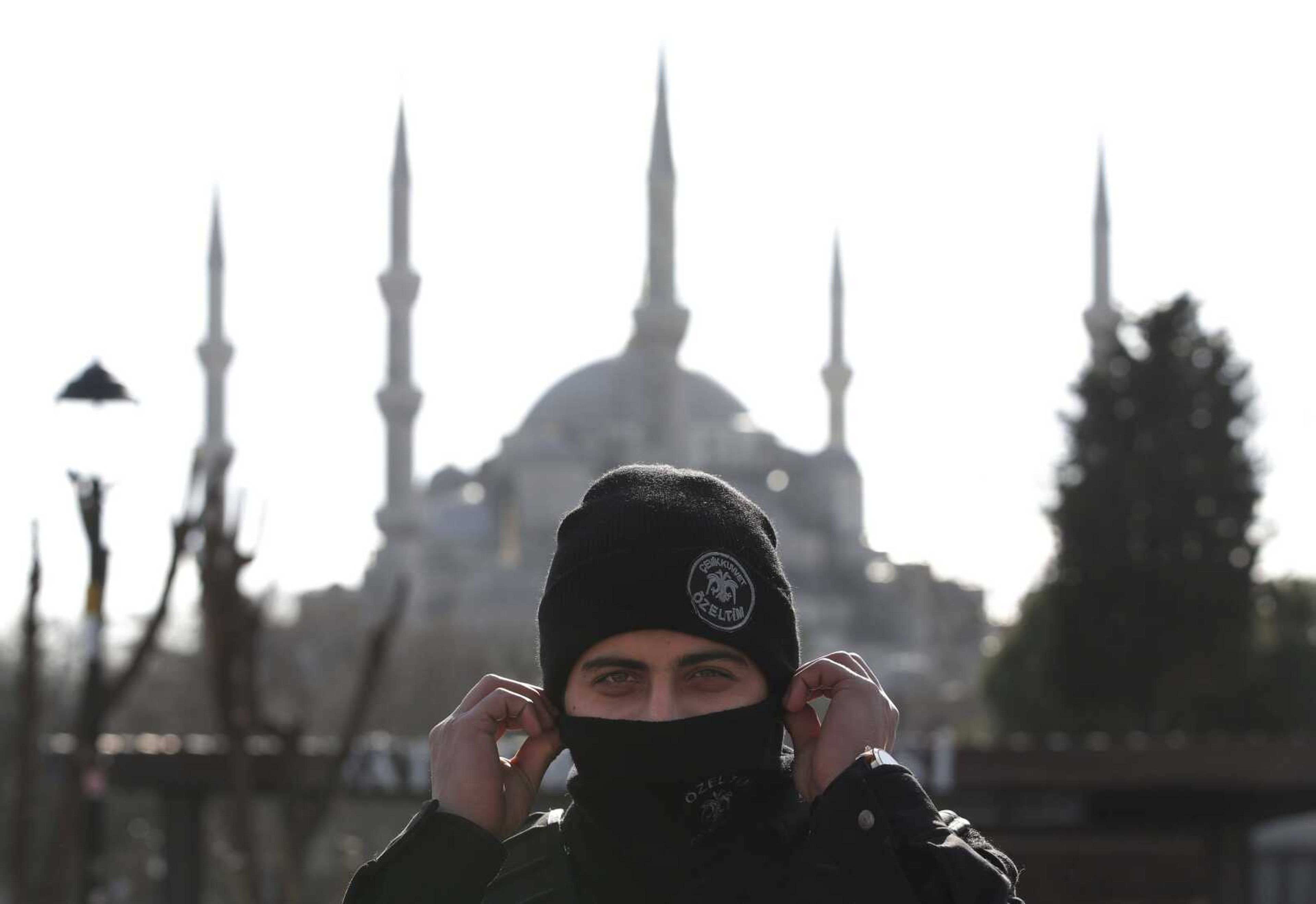 Backdropped by the Sultan Ahmed Mosque, better known as the Blue Mosque in the historic Sultanahmet district of Istanbul, a police officer secures the area after an explosion Tuesday that killed 10 people and wounded 15 others. (Lefteris Pitarakis ~ Associated Press)