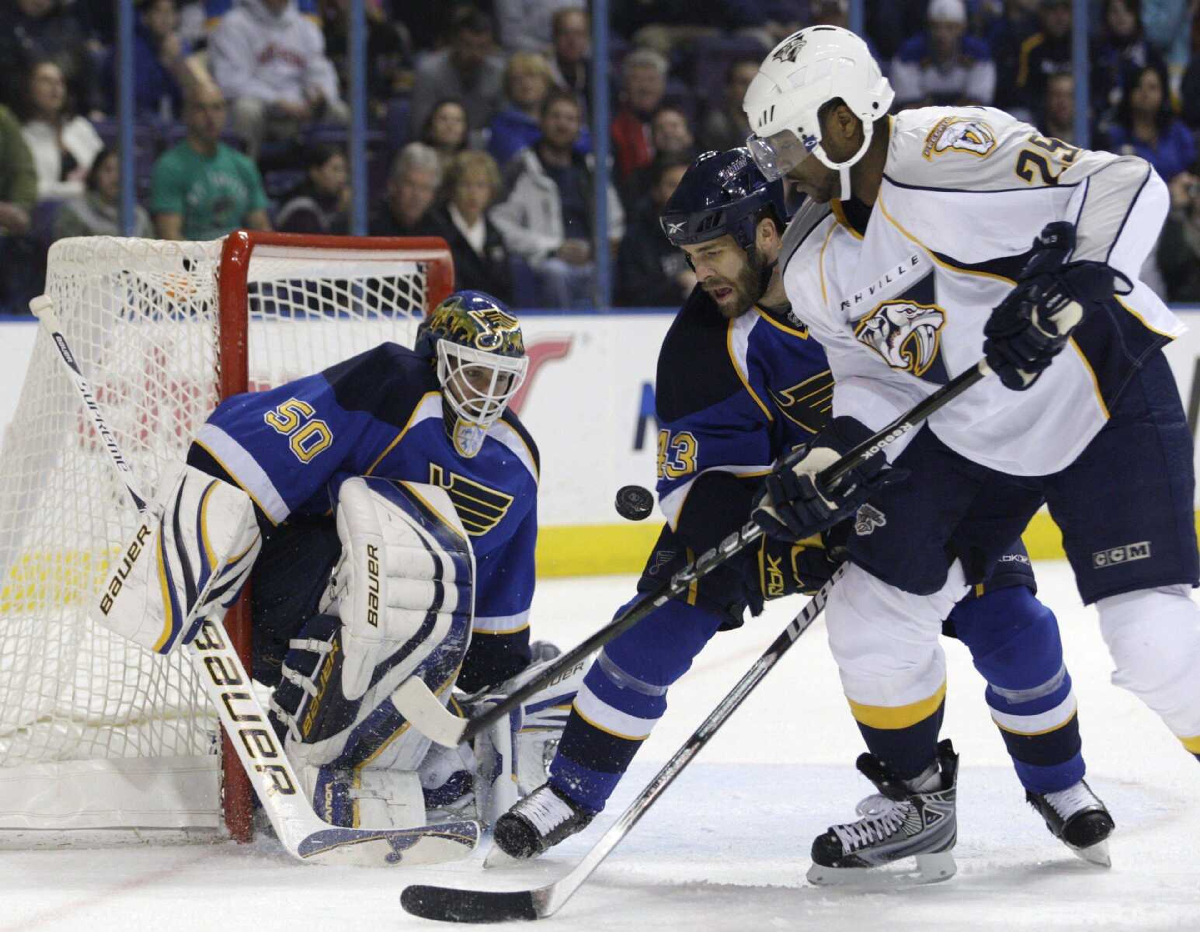 The Blues' Mike Weaver battles the Predators' Joel Ward for a rebound in front of goalie Chris Mason during the first period Sunday in St. Louis. (TOM GANNAM ~ Associated Press)