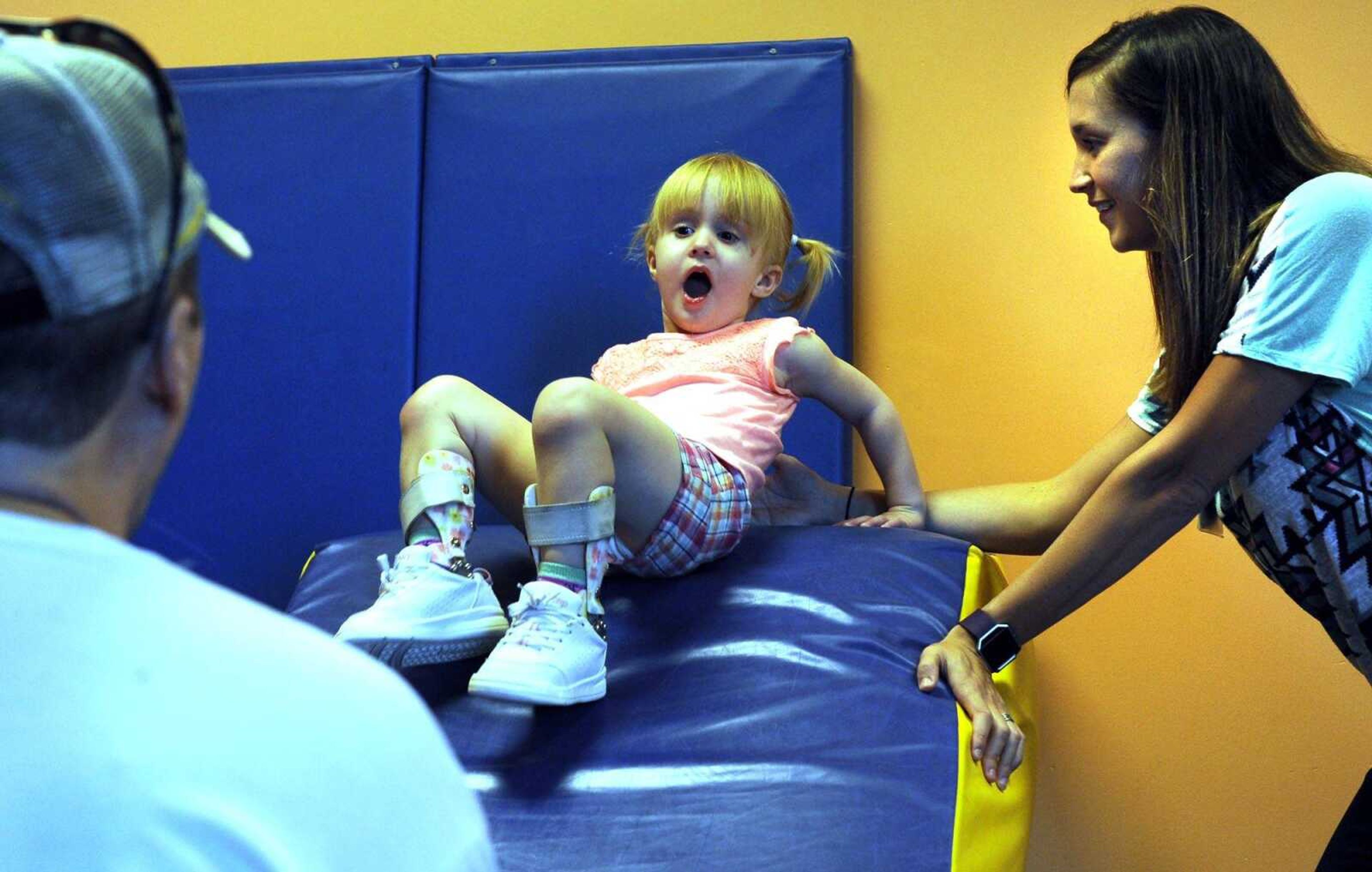 Jordyn Conn works with Malerie Essner, a physical therapist, as her father Randy Conn II assists, Thursday, Aug. 11, 2016 at HealthPoint Rehabilitation in Cape Girardeau.