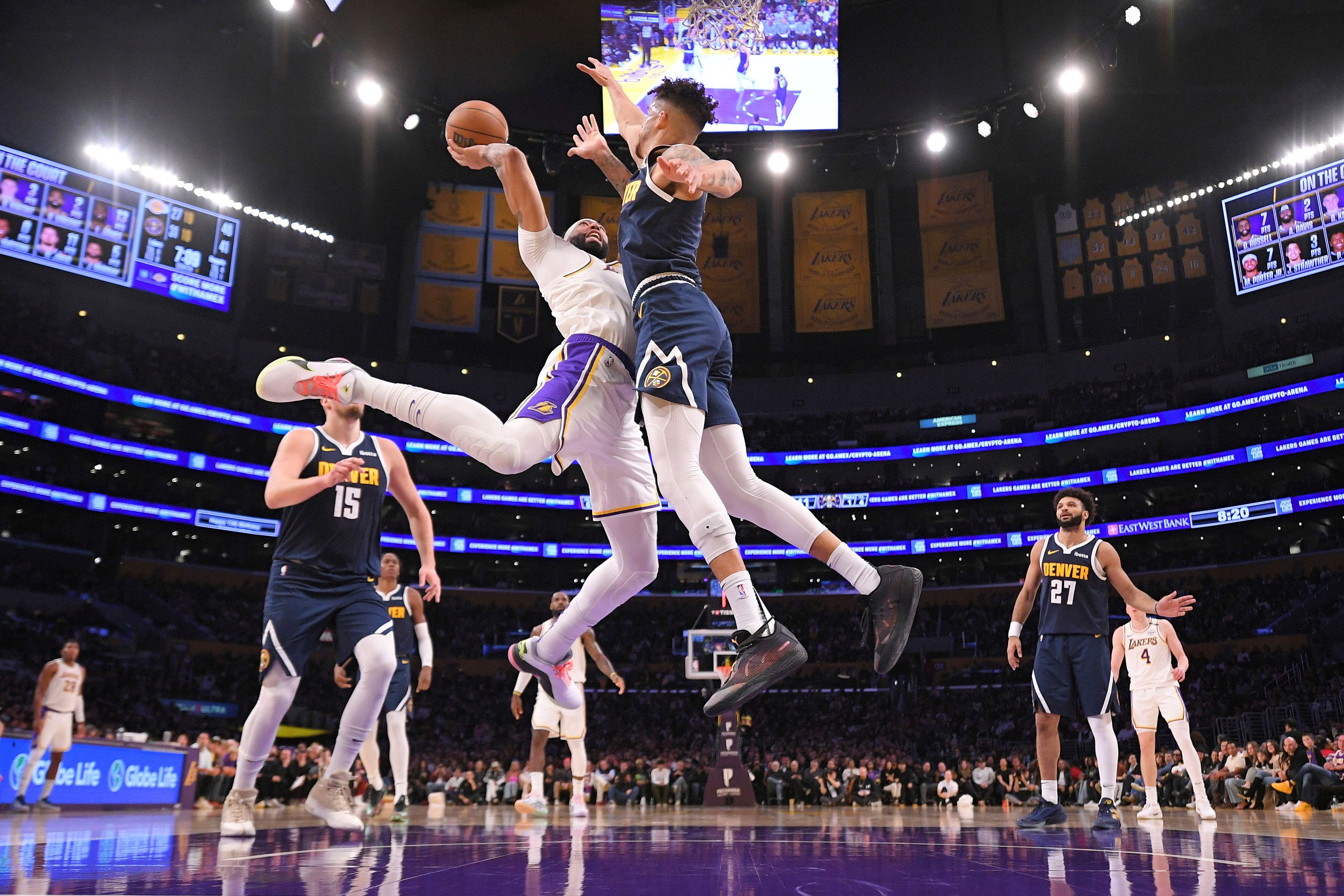 Los Angeles Lakers forward Anthony Davis, second from left, shoots as Denver Nuggets forward Michael Porter Jr. defends during the first half of an NBA basketball game, Saturday, Nov. 23, 2024, in Los Angeles. (AP Photo/Mark J. Terrill)