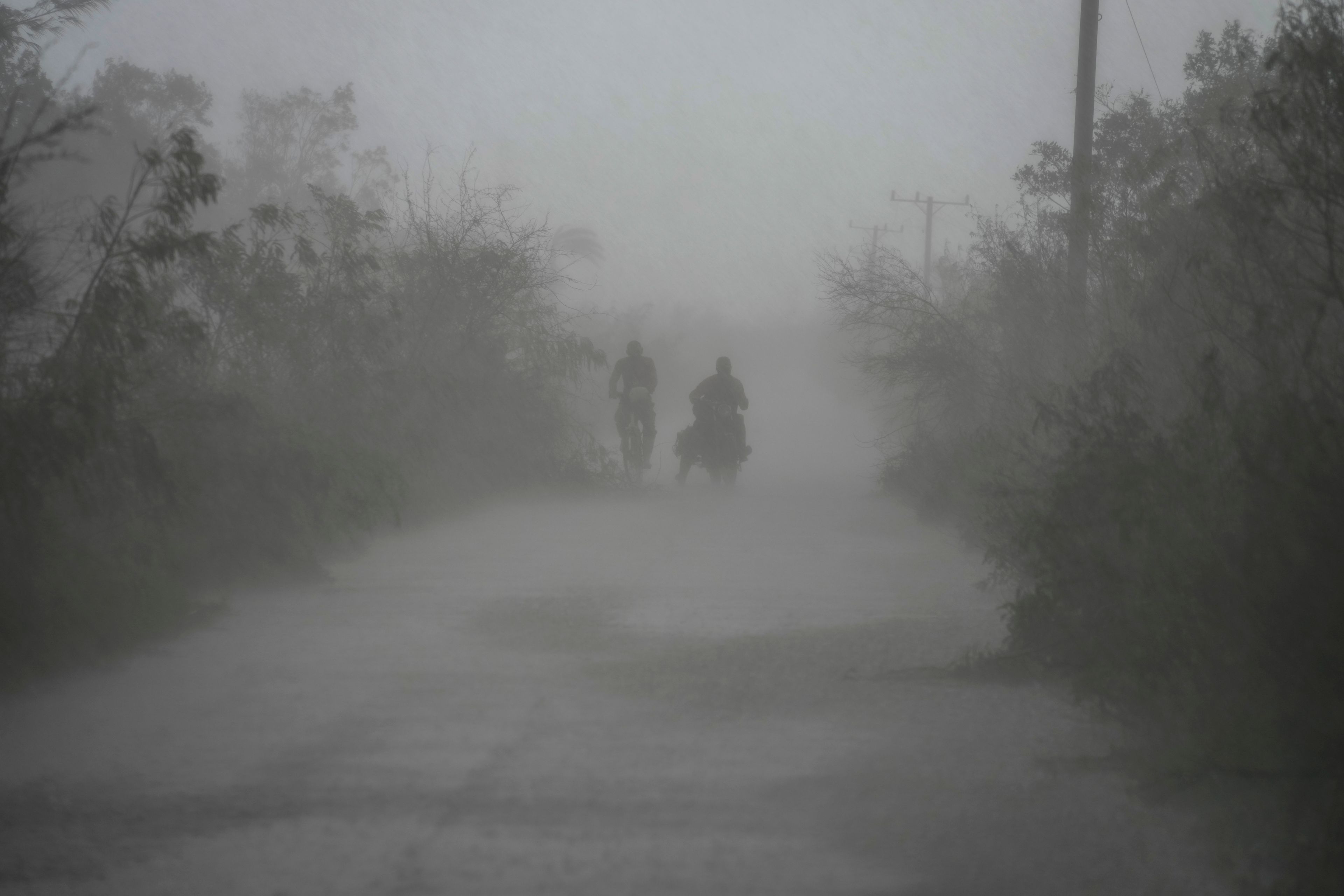 People travel in the rain after the passage of Hurricane Rafael in Guanimar, Cuba, Thursday, Nov. 7, 2024. (AP Photo/Ramon Espinosa)