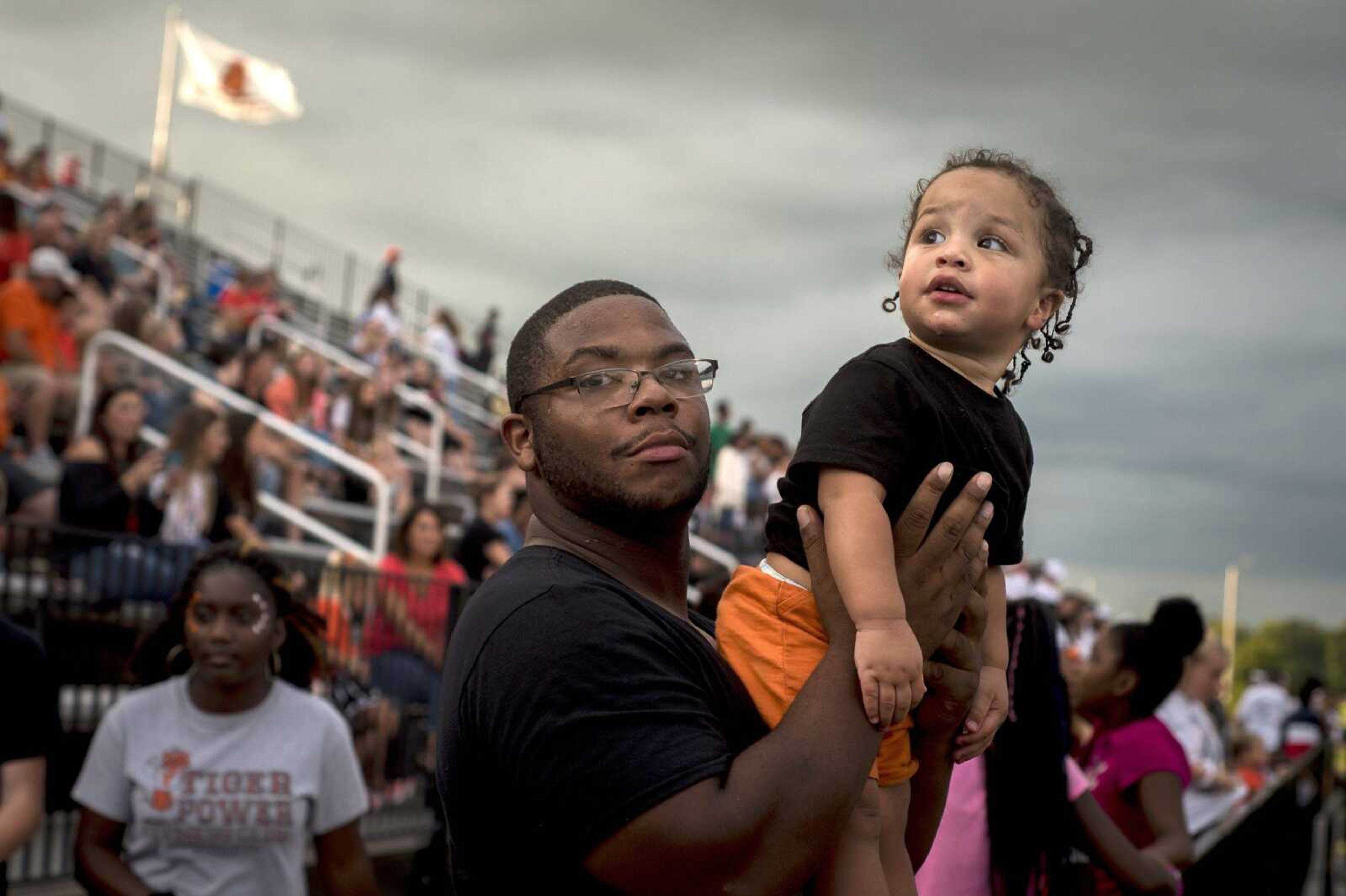 Robert Gafford holds his 1-year-old son, Kingston, in the stands before the Cape Central Tigers' first home football game.