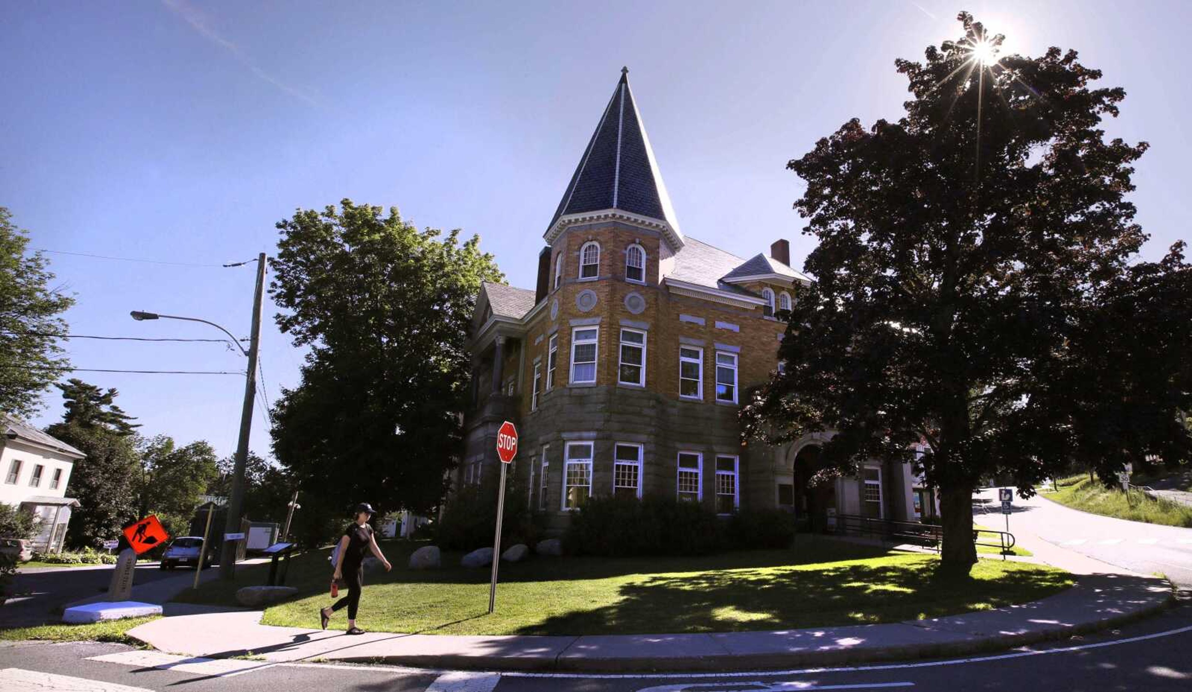 A library patron freely crosses the United States border from Quebec into Vermont as she walks down the sidewalk during a July 11 visit to the Haskell Library, rear, in Derby Line, Vermont. While the Trump administration fortifies the southern border, there's growing concern over the number of foreigners entering the country illegally across the porous northern border with Canada.