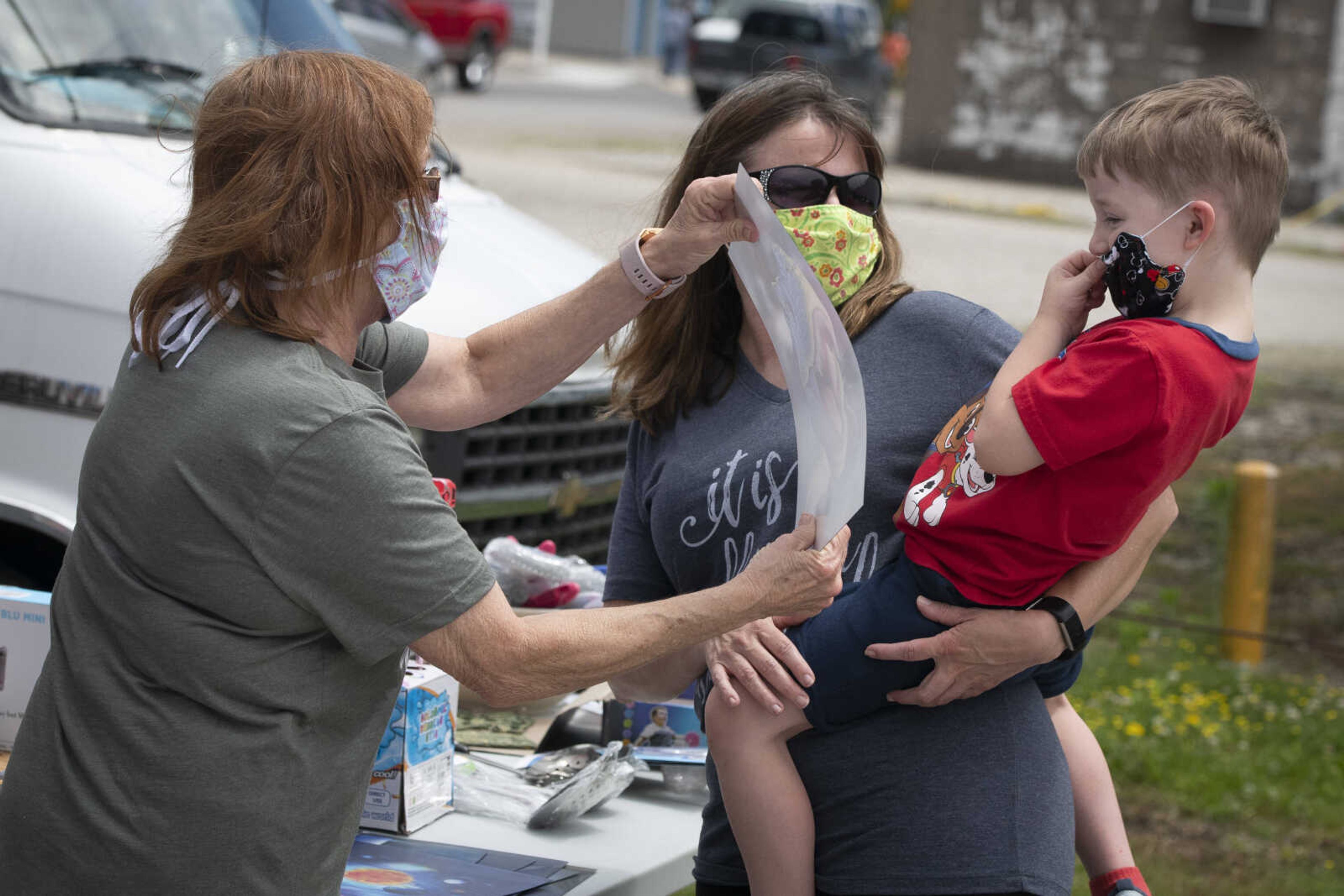 Jace Brooks, 4, of Bloomfield, Missouri, (being held by his mother April Bond of Bloomfield) reacts to his grandmother Margie Robinson of Advance, Missouri, holding up a dinosaur poster at a sale in Delta during the 100-Mile Yard Sale on Saturday, May 23, 2020, along Highway 25. The sale takes place along Highway 25 from Jackson to Kennett, Missouri, and runs through Memorial Day.