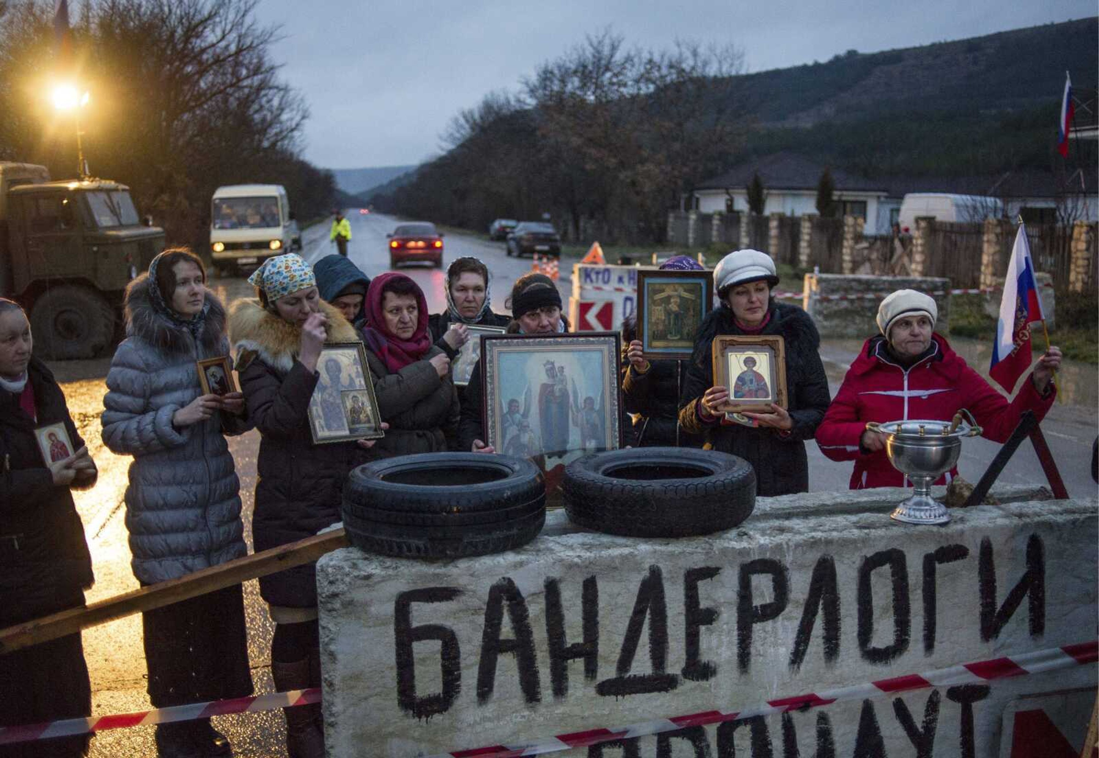 Pro-Russian activists hold up Orthodox icons at a checkpoint Thursday outside the Ukrainian Black Sea port of Sevastopol in the Crimea, Ukraine. The banner reads &#8220;Banderlogs not pass,&#8221; a phrase based on a Hindi word for monkeys and impugning all anti-Yanukovych supporters as vacuous, chattering people. (Andrew Lubimov ~ Associated Press)