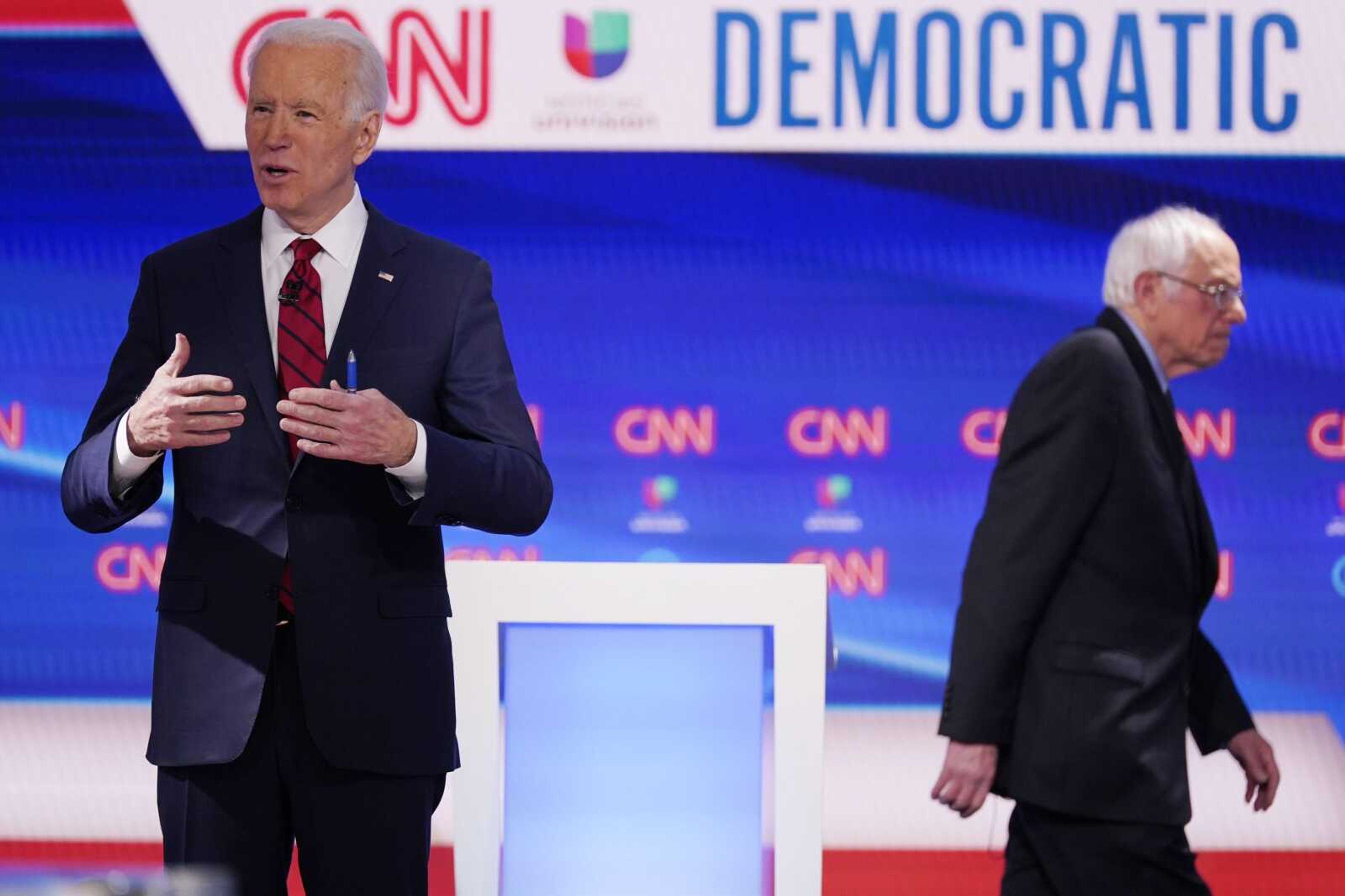 Sen. Bernie Sanders, I-Vt., walks back to his podium to join former Vice President Joe Biden, in a Democratic presidential primary debate Sunday in Washington.