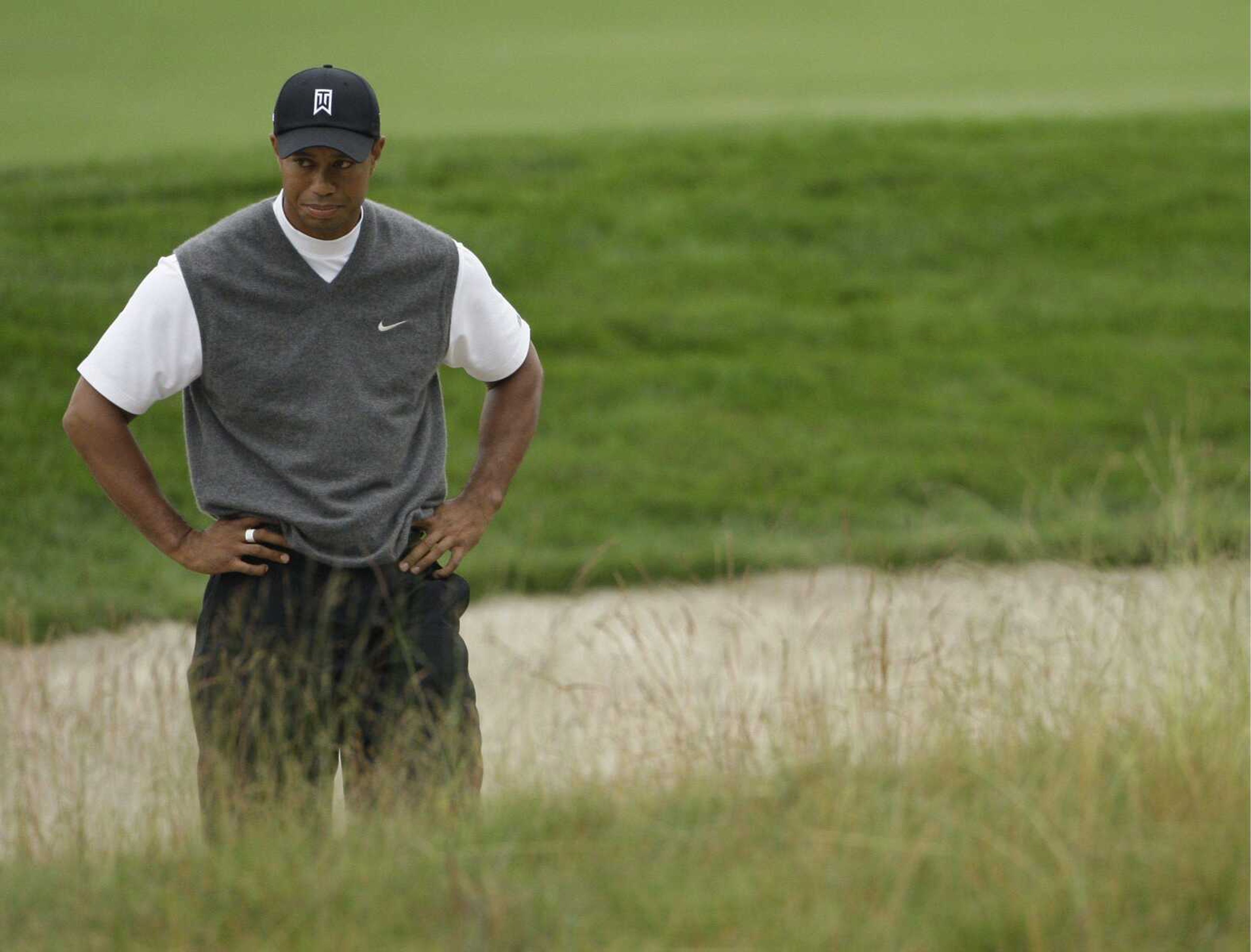 Defending champion Tiger Woods stands next to his ball in the rough off the 10th green during his first round at the U.S. Open. (MORRY GASH ~ Associated Press)