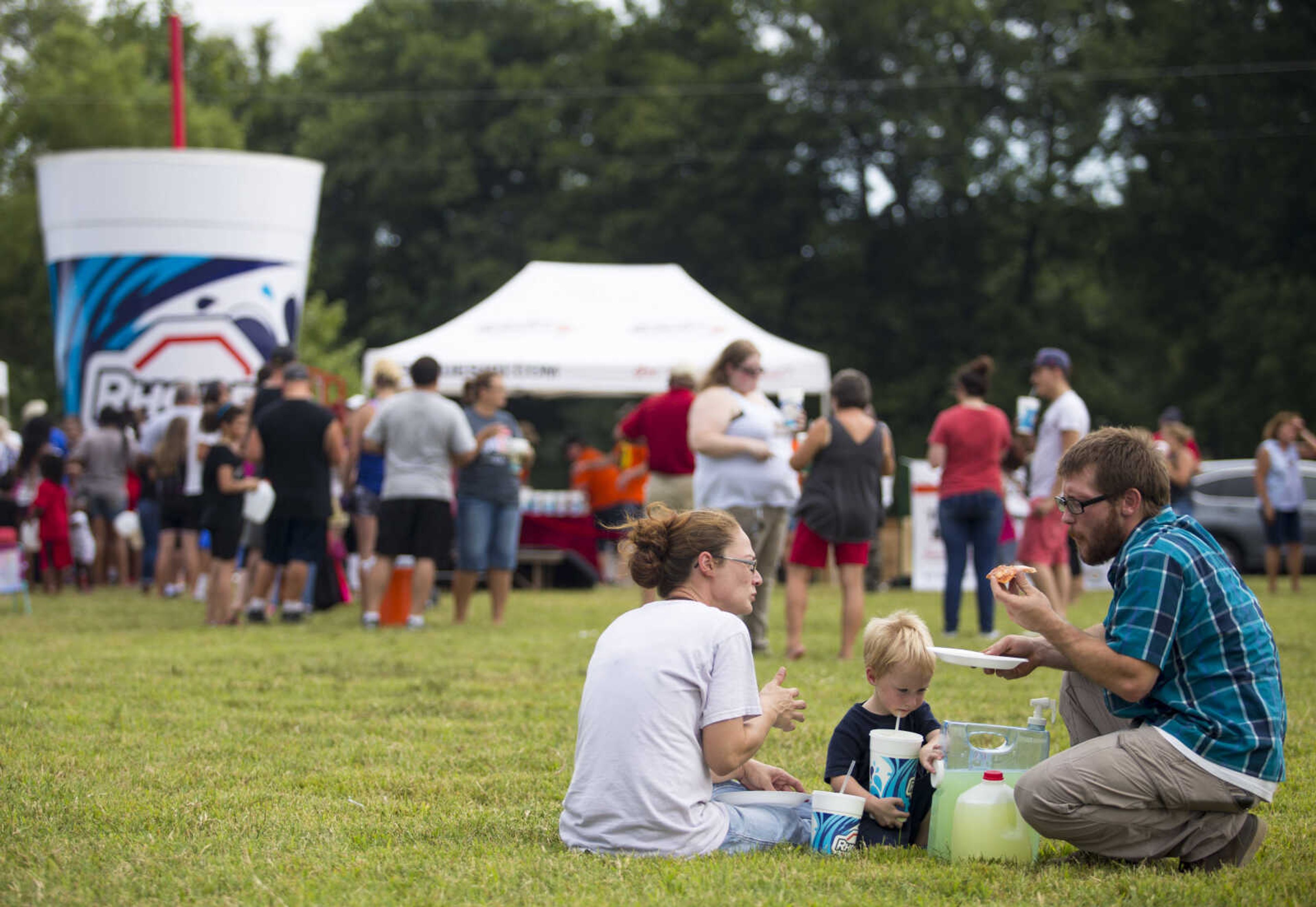 Nick Hayes, right, and his son Finley, 2, enjoy free lemonade and Imo's Pizza with Chrystal Martin at Mercato Di Rodi in Cape Girardeau Sunday afternoon.