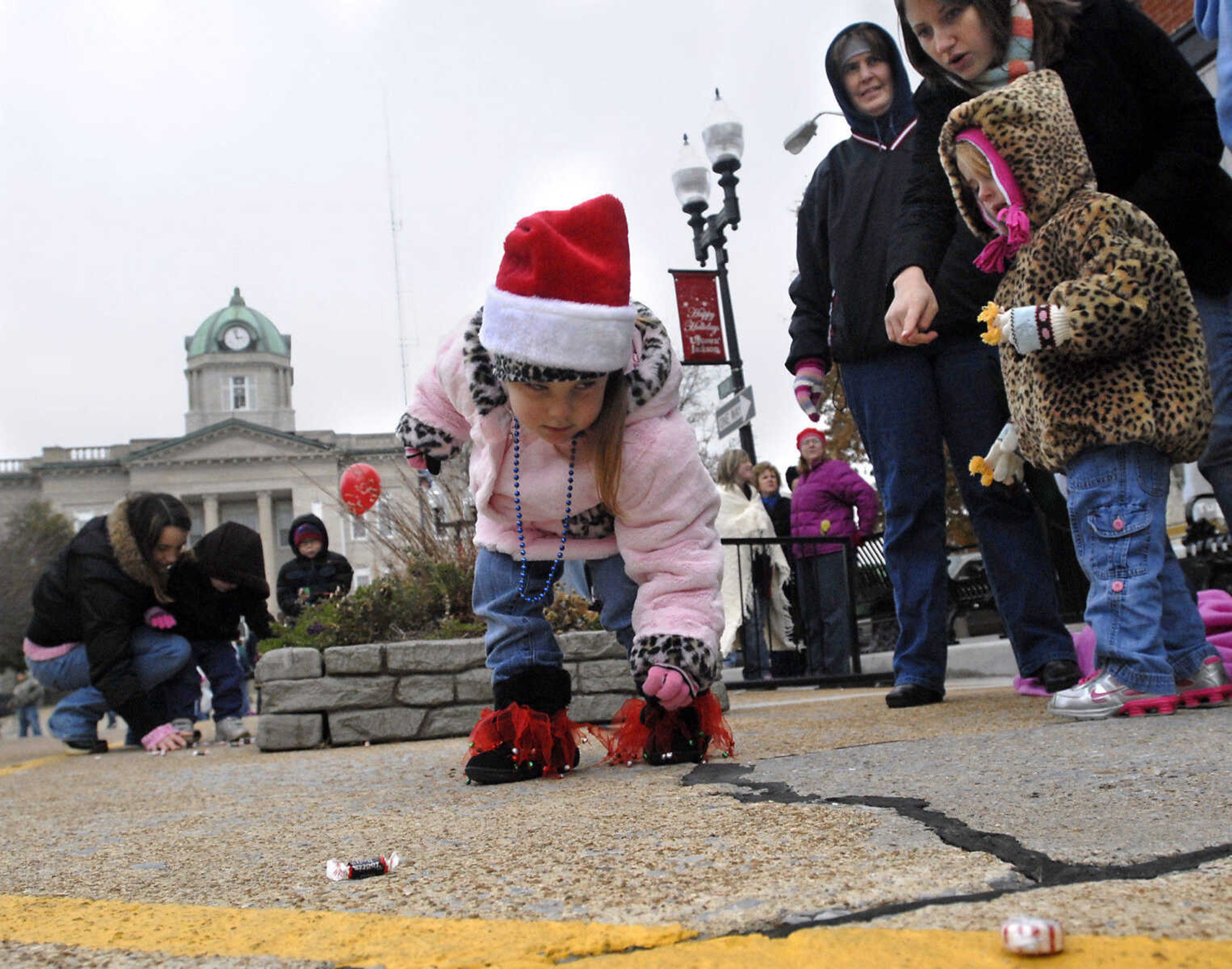 KRISTIN EBERTS ~ keberts@semissourian.com

Marandia Rhodes, 3, picks up candy while her cousin Lexi Stearns, 3, aunt Jessica Stearns, and grandmother Pam Stearns, from right, watch during the Jackson Christmas Parade on Saturday, Dec. 4, 2010, in downtown Jackson.