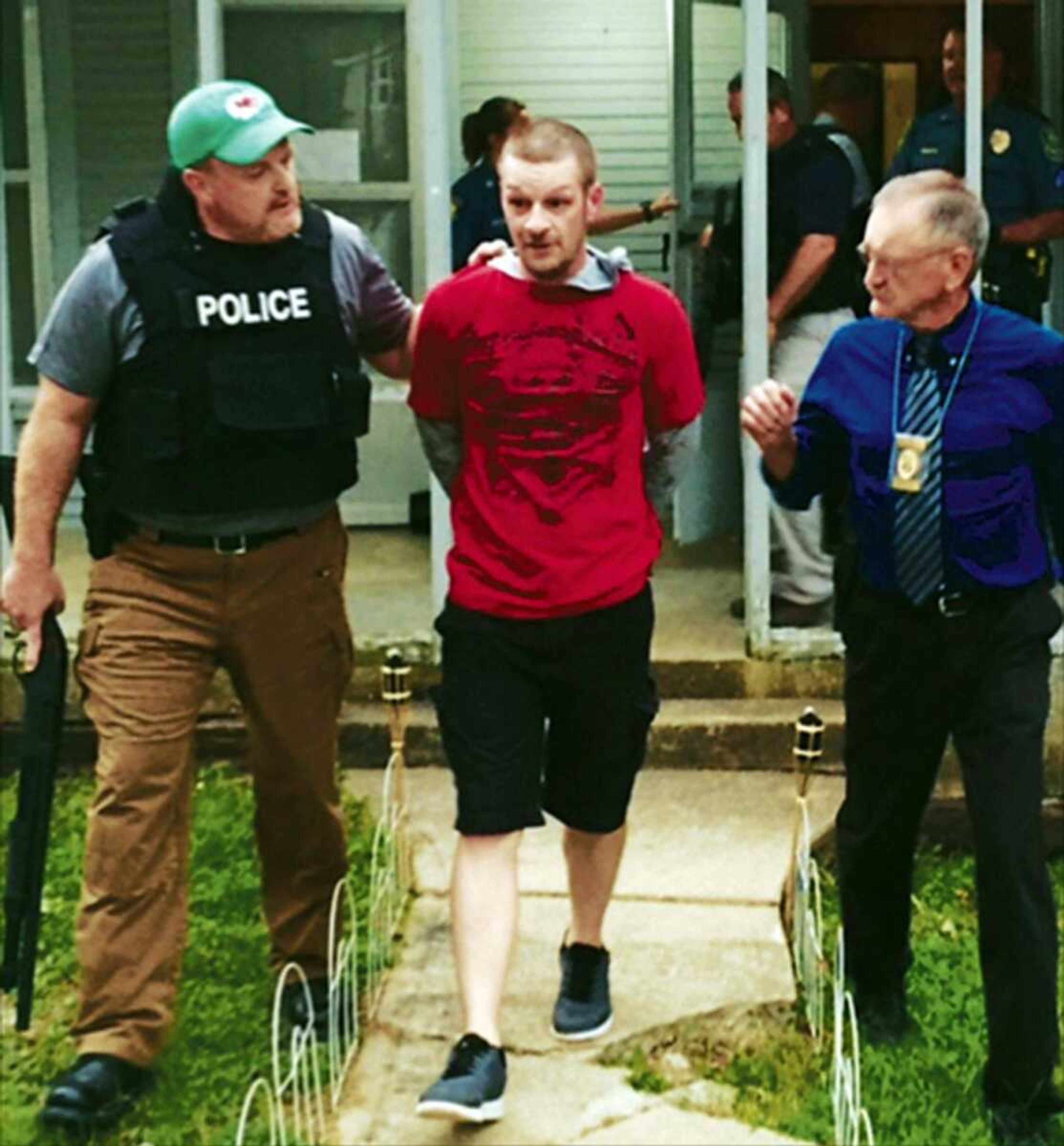 Butler County Sheriff Mark Dobbs, left, and Poplar Bluff police chief Danny Whiteley, right, escort murder suspect Eric Wyatt from a home in Poplar Bluff, Missouri.