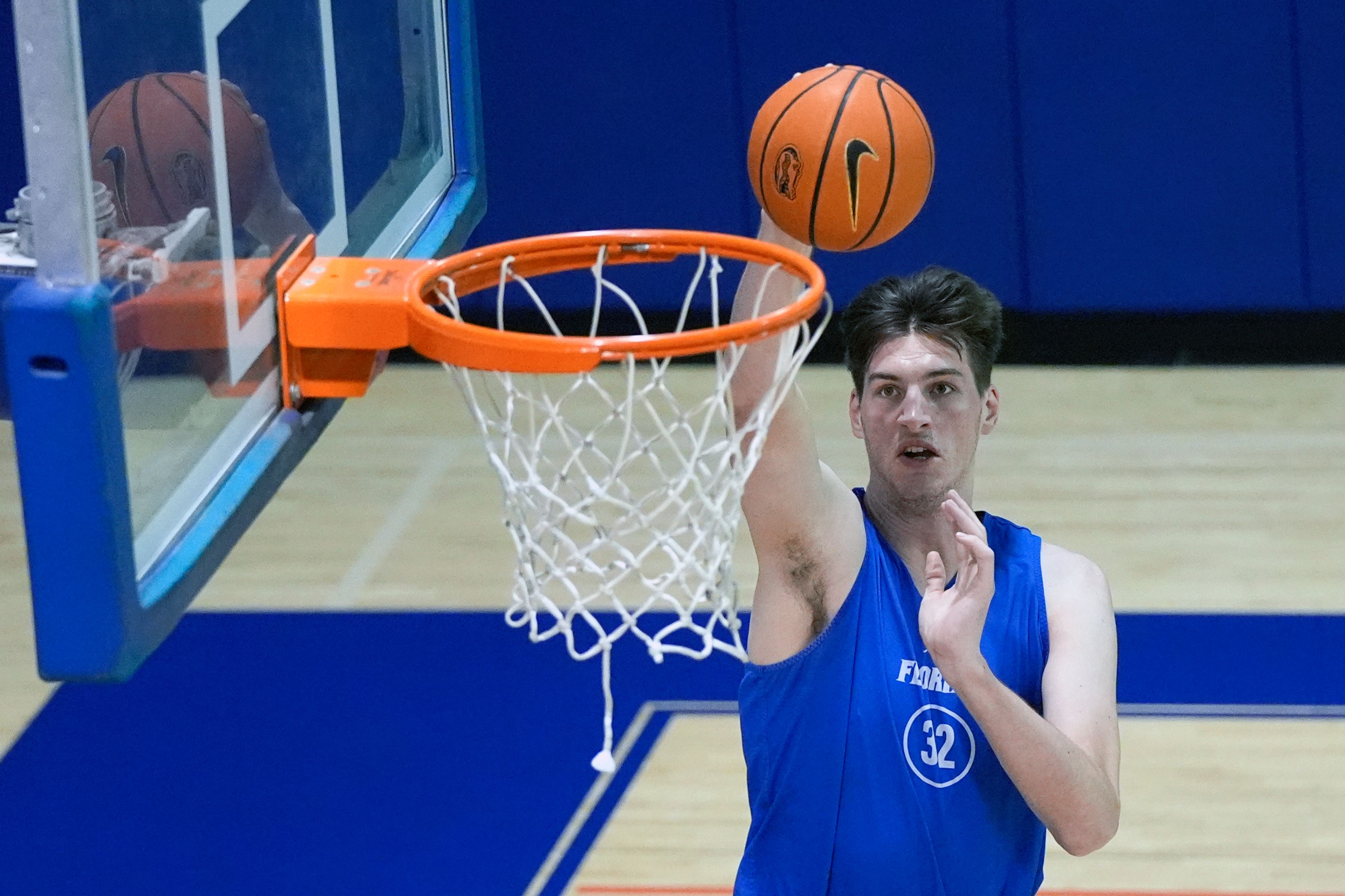 Olivier Rioux, a 7-foot-9 NCAA college basketball player at Florida, dunks the ball as he practices with the team, Friday, Oct. 18, 2024, in Gainesville, Fla. (AP Photo/John Raoux)