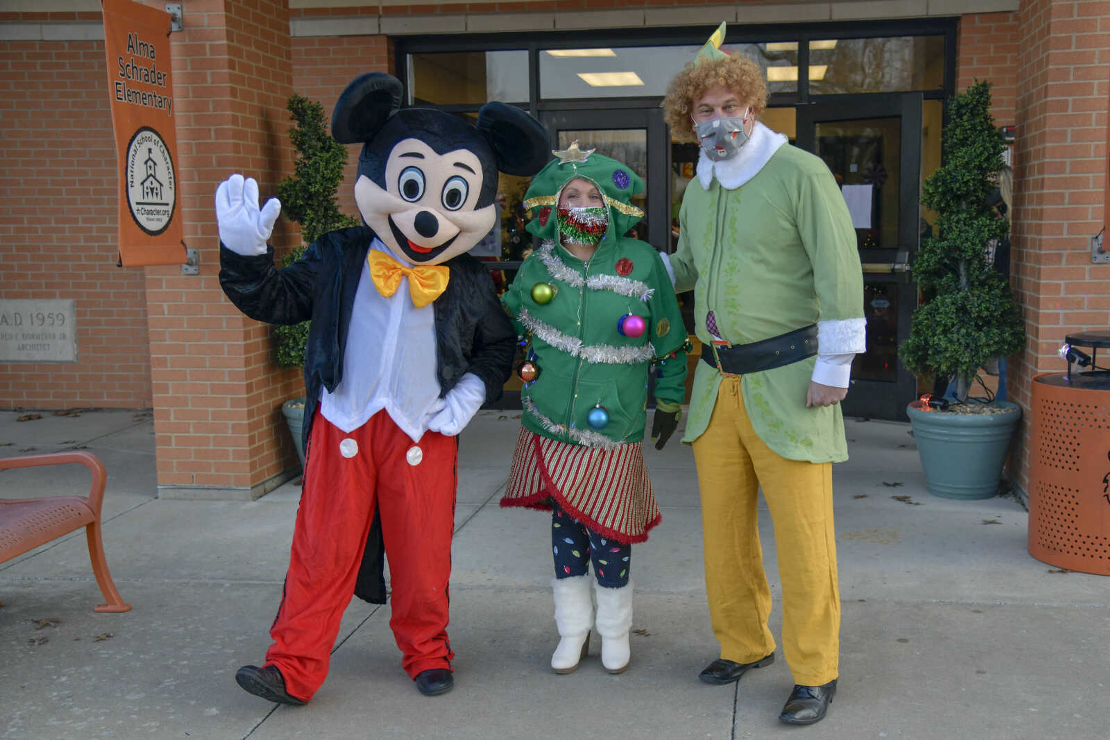 From left, Assistant Superintendent Josh Crowell as Mickey Mouse, Psychological Examiner Stephanie Craft as a Christmas tree and Superintendent Dr. Neil Glass as Buddy the Elf pose for a photo at Alma Schrader Elementary School in Cape Girardeau on Thursday, Dec. 17, 2020.