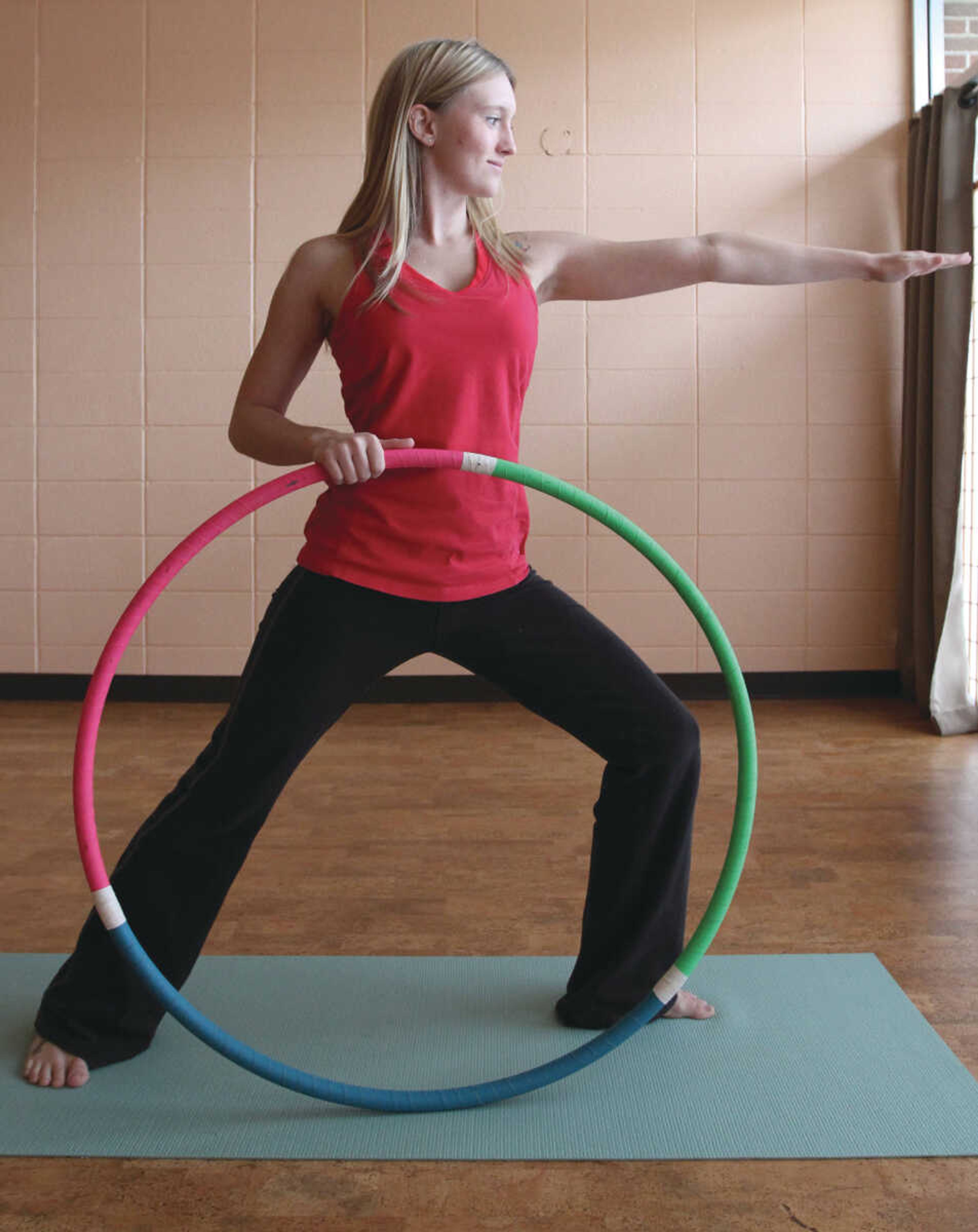 Tabby Martin, a registered yoga teacher at Yoga East in Cape Girardeau, performs a Warrior II pose using a hoop for balance. (Glenn Landberg)