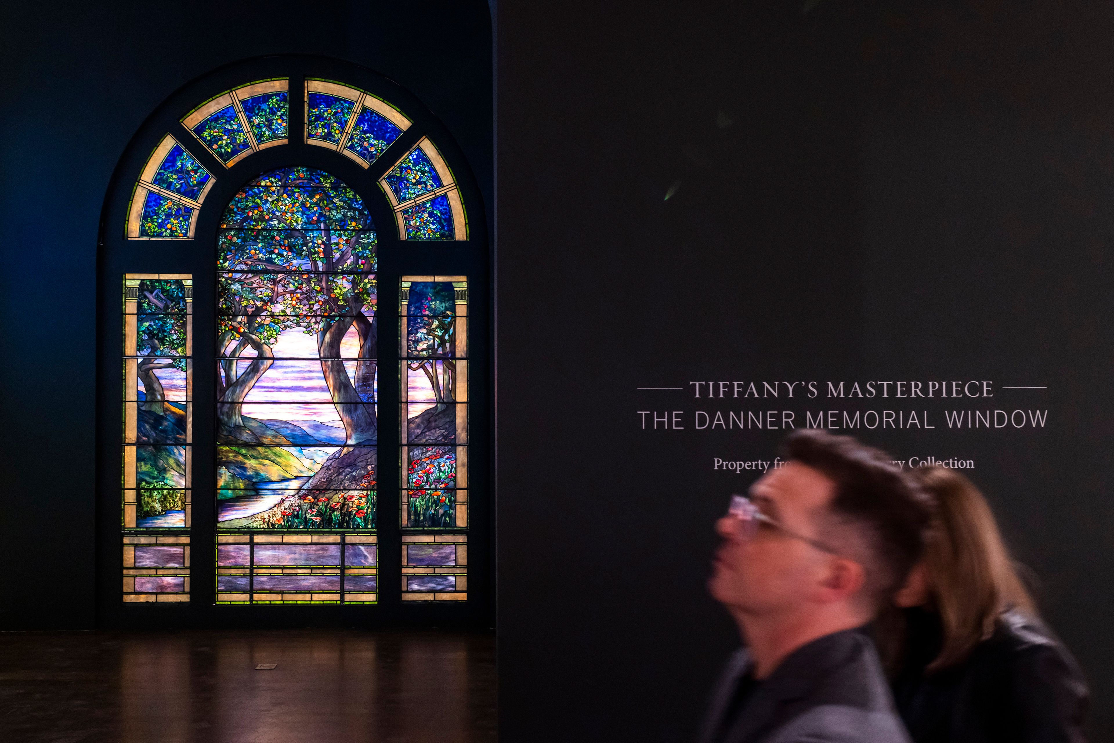 People walk near The Danner Memorial Window, by Tiffany Studios during an auction preview at Sotheby's in New York, Monday, Nov. 11, 2024. (AP Photo/Eduardo Munoz Alvarez)