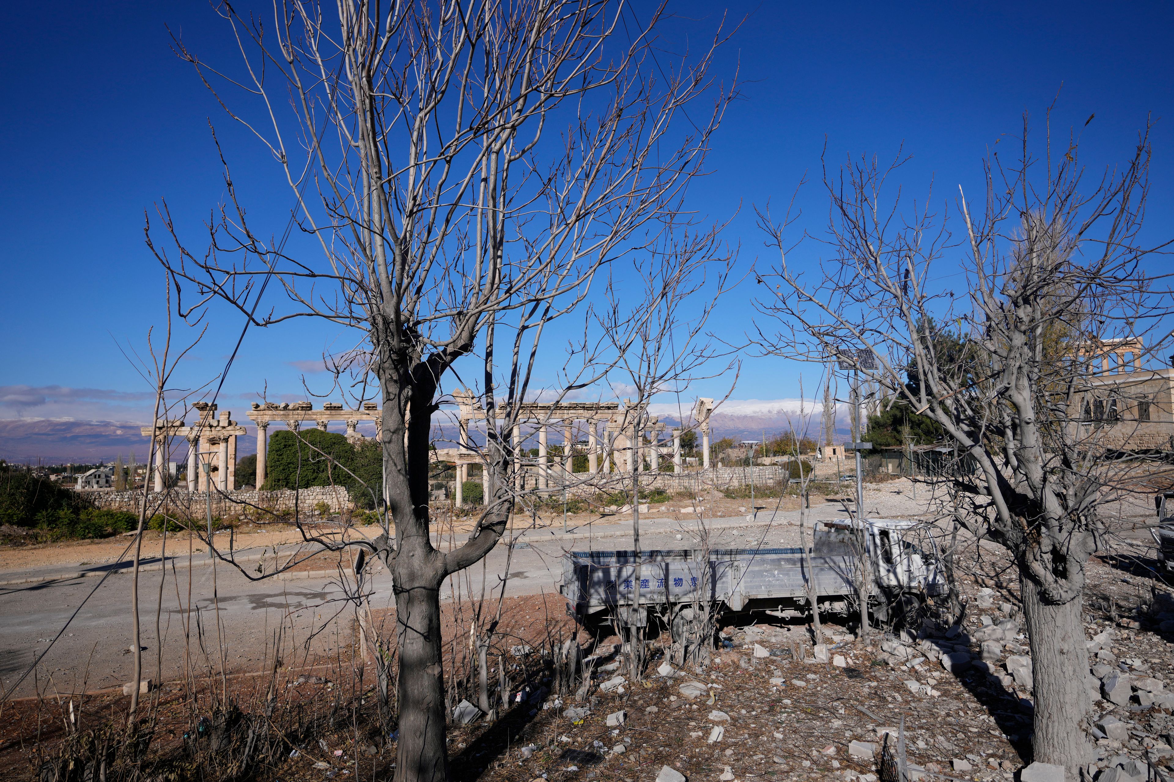 Damaged vehicles are seen in front of the Roman temples of Baalbek in eastern Lebanon, Thursday, Nov. 28, 2024. (AP Photo/Hassan Ammar)