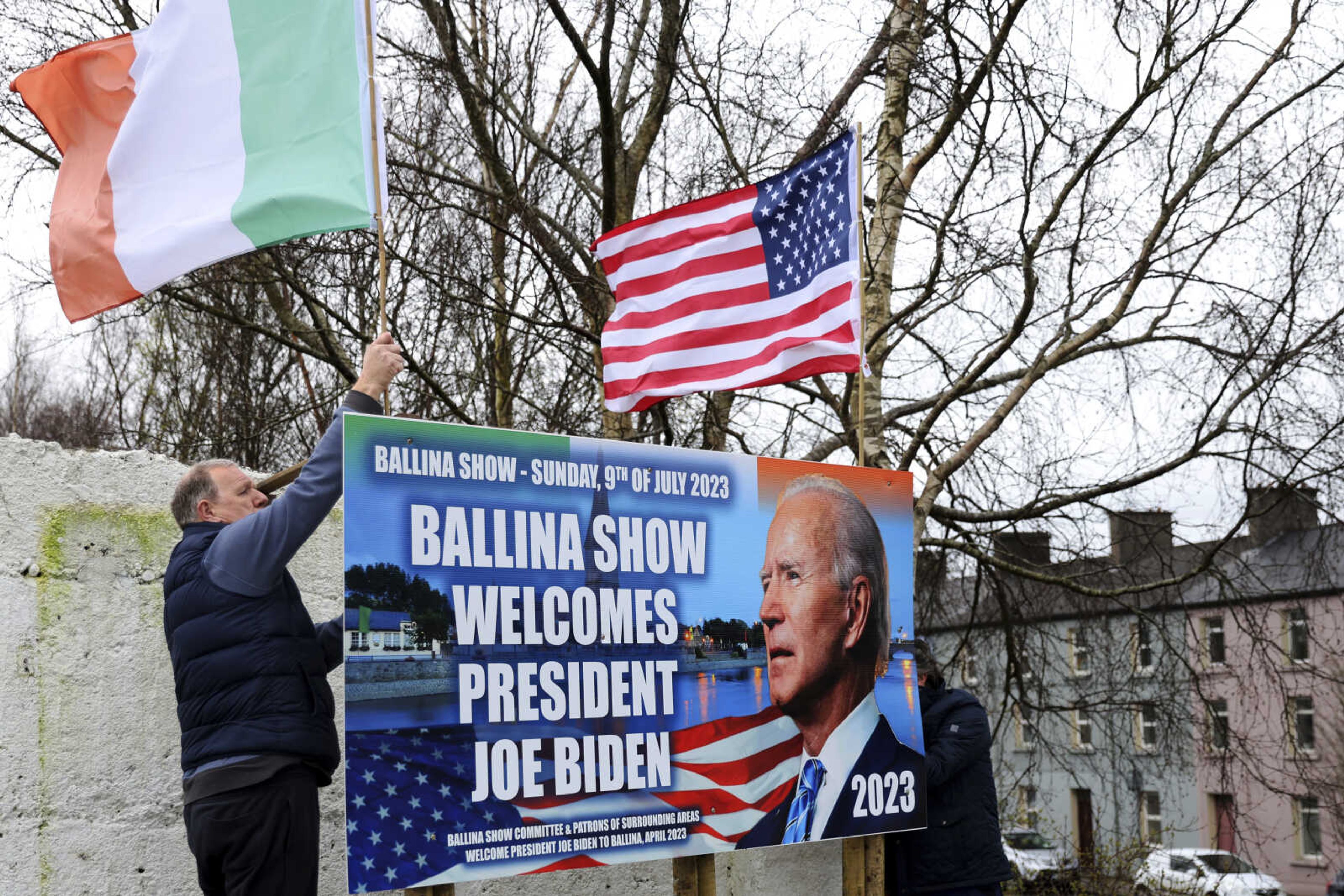 Ray Clarke, left, and Eddie Ruane put up flags April 4 in Ballina, Ireland. Ballina was home to some of President Joe Biden's ancestors. Biden is scheduled to visit the town this week, part of a four-day trip to Ireland and neighboring Northern Ireland.