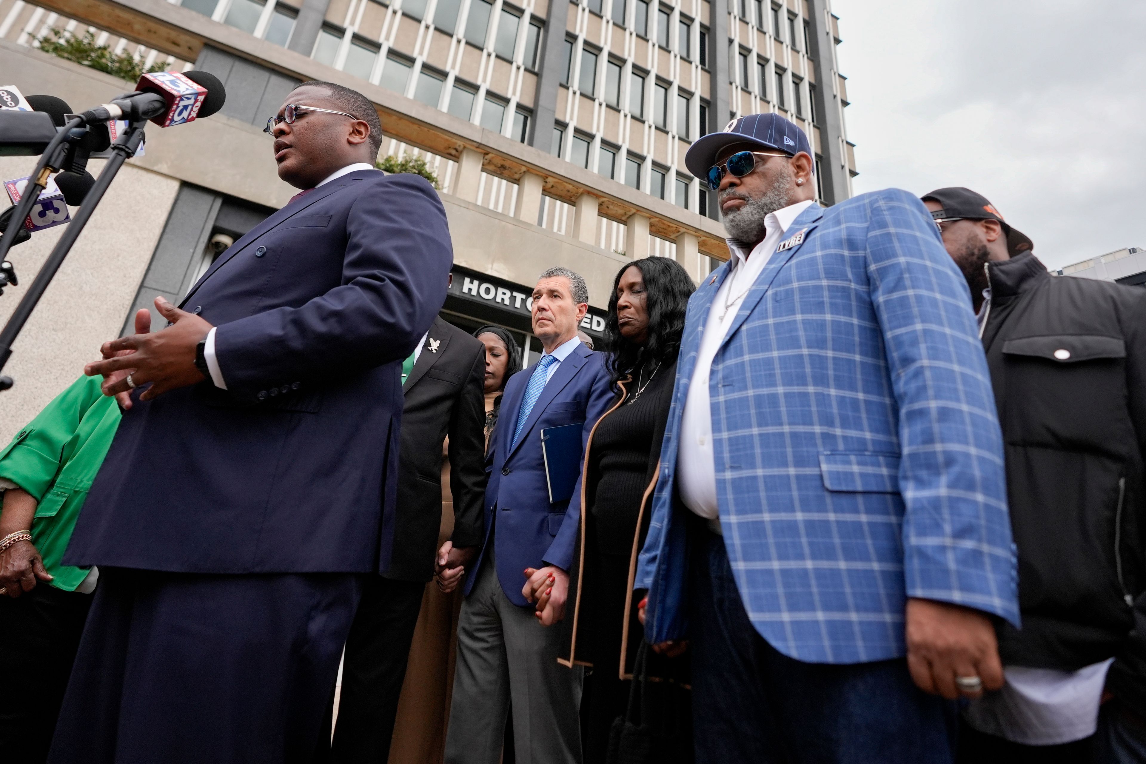 Rev. J. Lawrence Turner, left, leads a prayer vigil with the mother and stepfather of Tyre Nichols, RowVaughn Wells, second from right, and Rodney Wells, right, outside the federal courthouse during the trial of three former Memphis police officers accused of killing her son Wednesday, Sept. 25, 2024, in Memphis, Tenn. (AP Photo/George Walker IV)