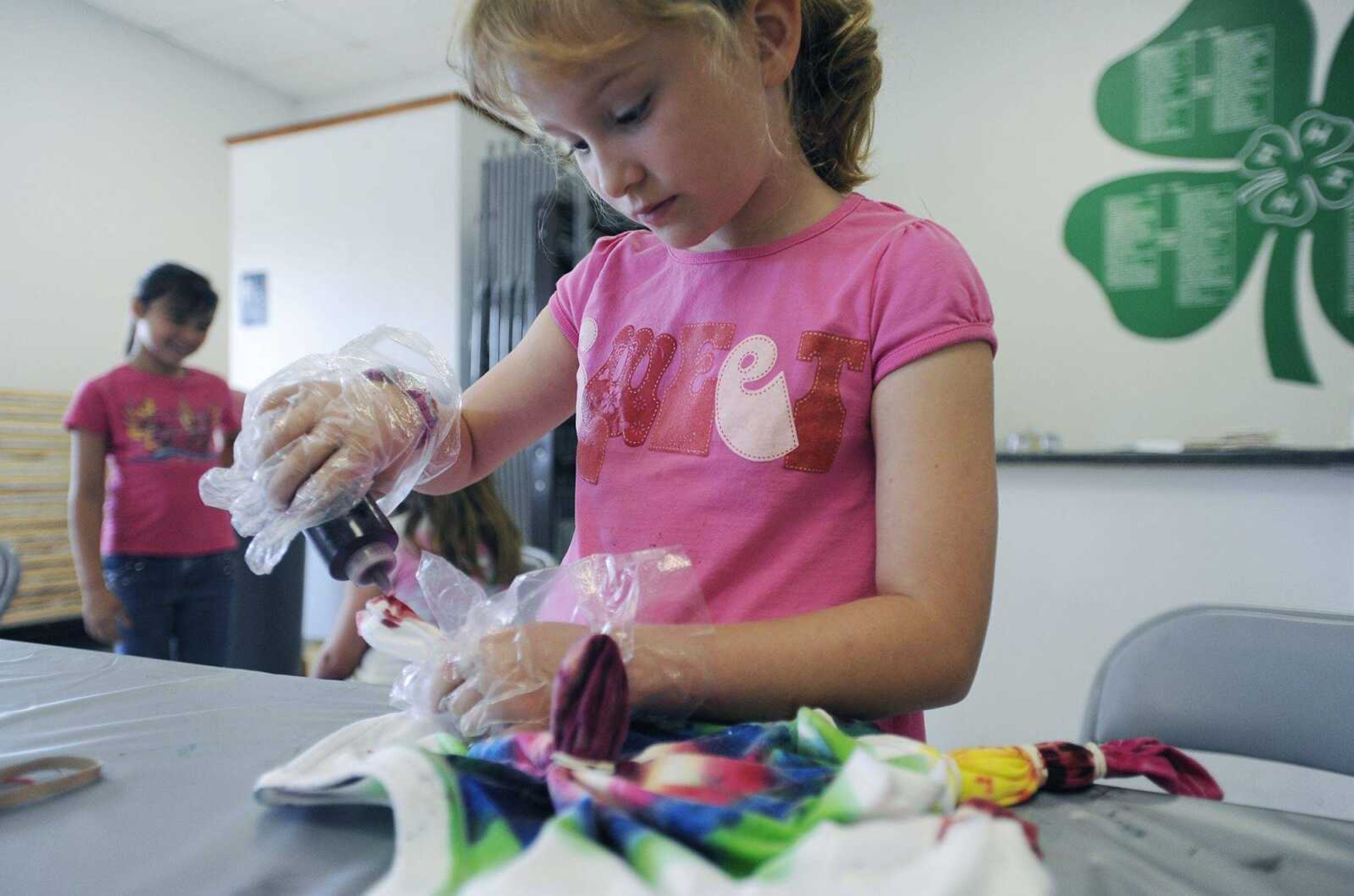 Clara Bledsoe works on her tie-dye shirt Wednesday at the Cape Girardeau Parks and Recreation Department's Arting Around day camp. (CAROL KELLISON)