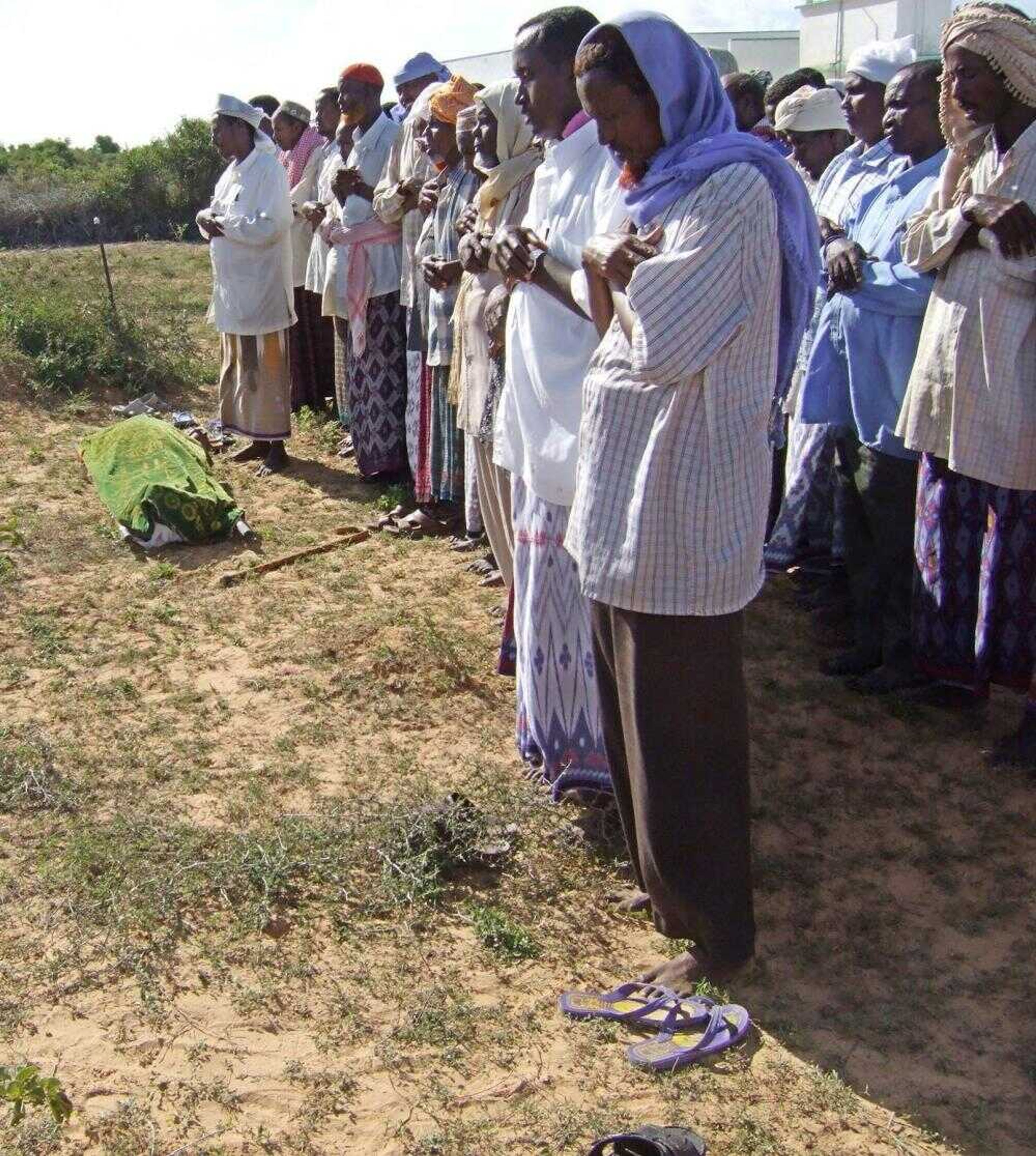 Somalis prayed Saturday over the body of Howlwadaag district chairman Hassan Ali Sa'id, left, in Mogadishu, Somalia. Unknown gunmen killed Sa'id in the capital's southern neighborhood late Saturday as he was about to enter his house, a neighbor said. (Mohamed Sheikh Nor ~ The Associated Press)