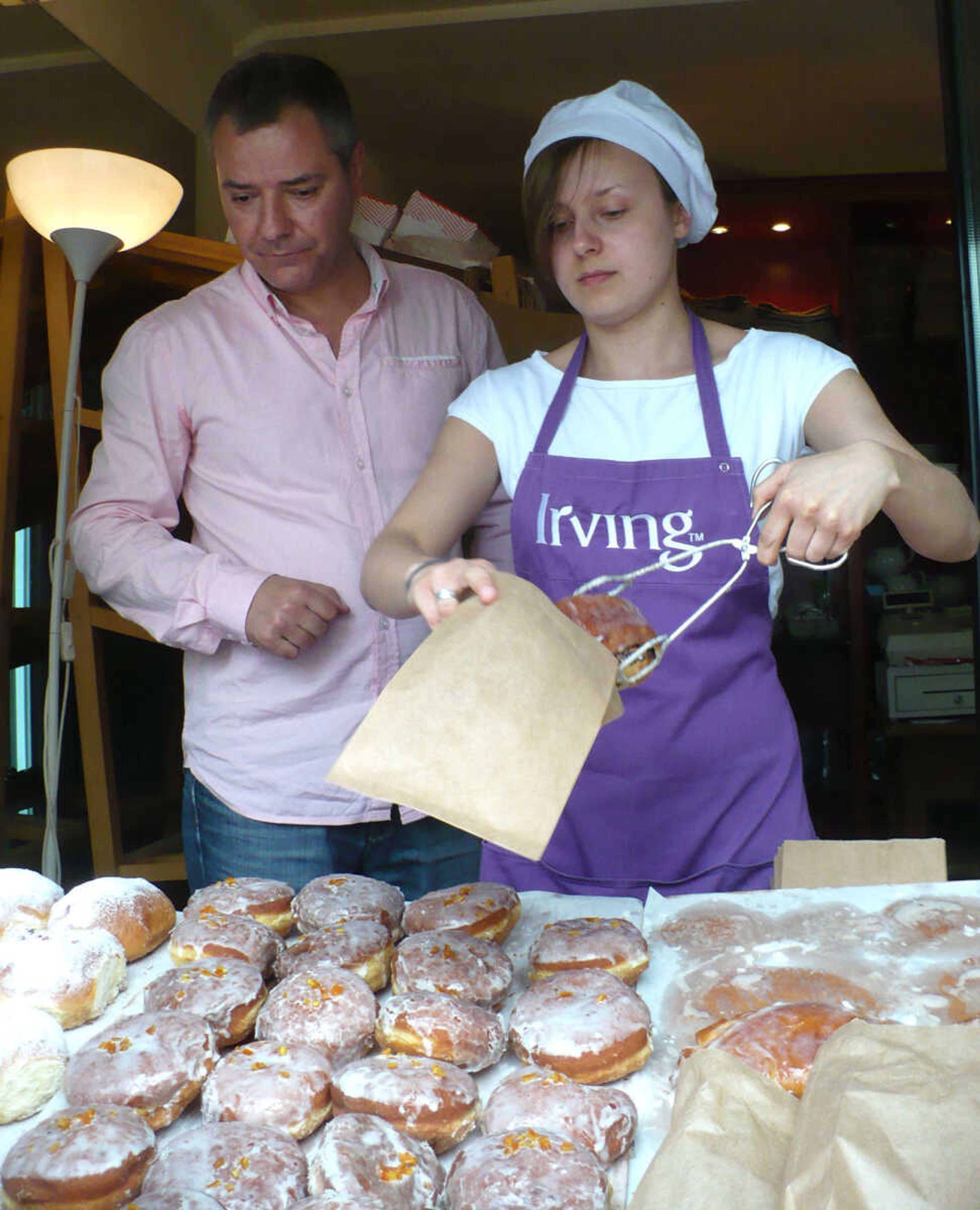 Vendors in Warsaw, Poland, offer typical Polish doughnuts to passersby.