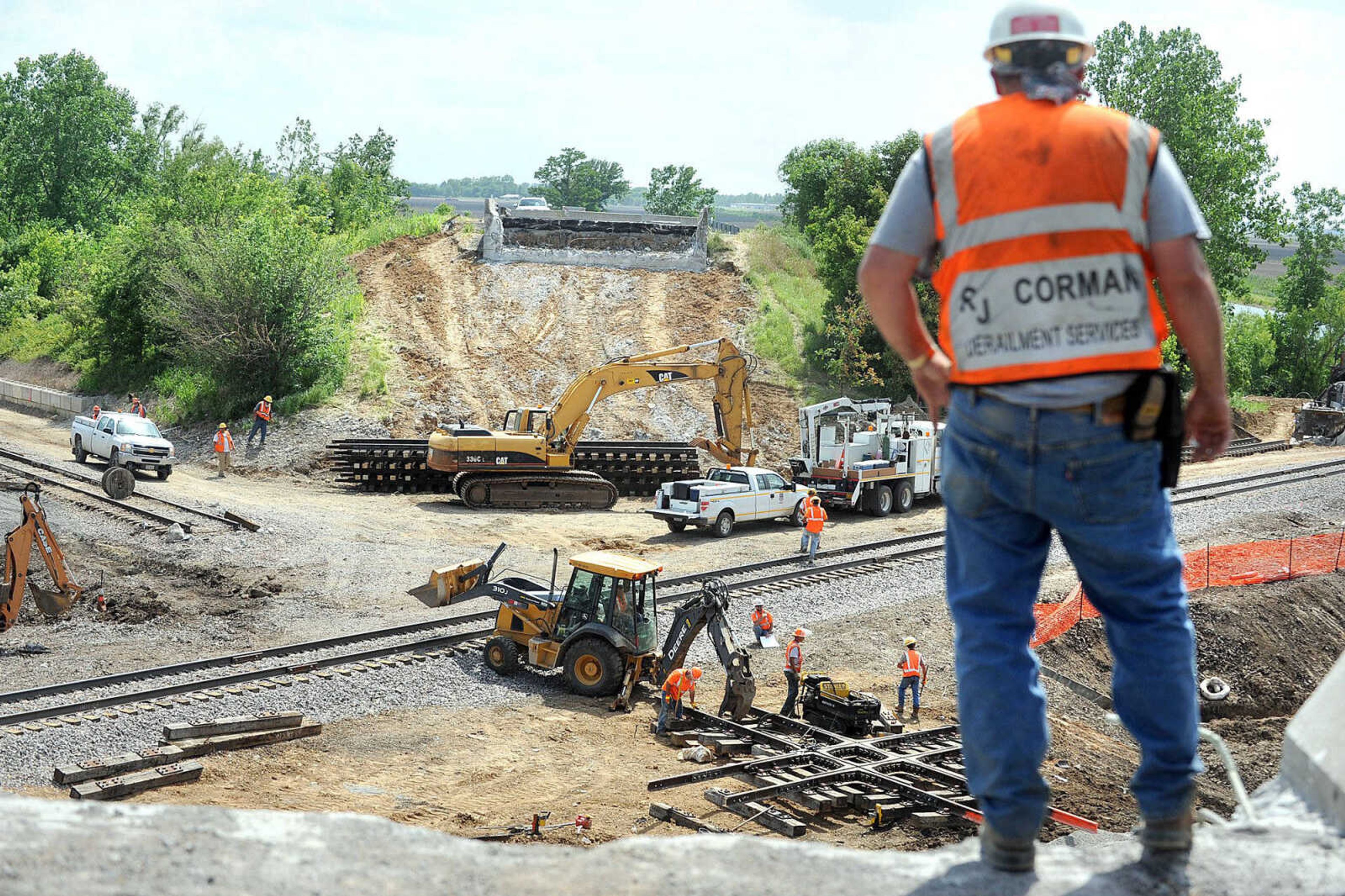 Greg Esthers with RJ Corman Derailment Services stands at the edge of where the Route M overpass once stood Wednesday in Rockview, Mo. Crews are cleaning up the area where two trains collided Saturday, causing the Route M overpass to collapse. (Laura Simon)