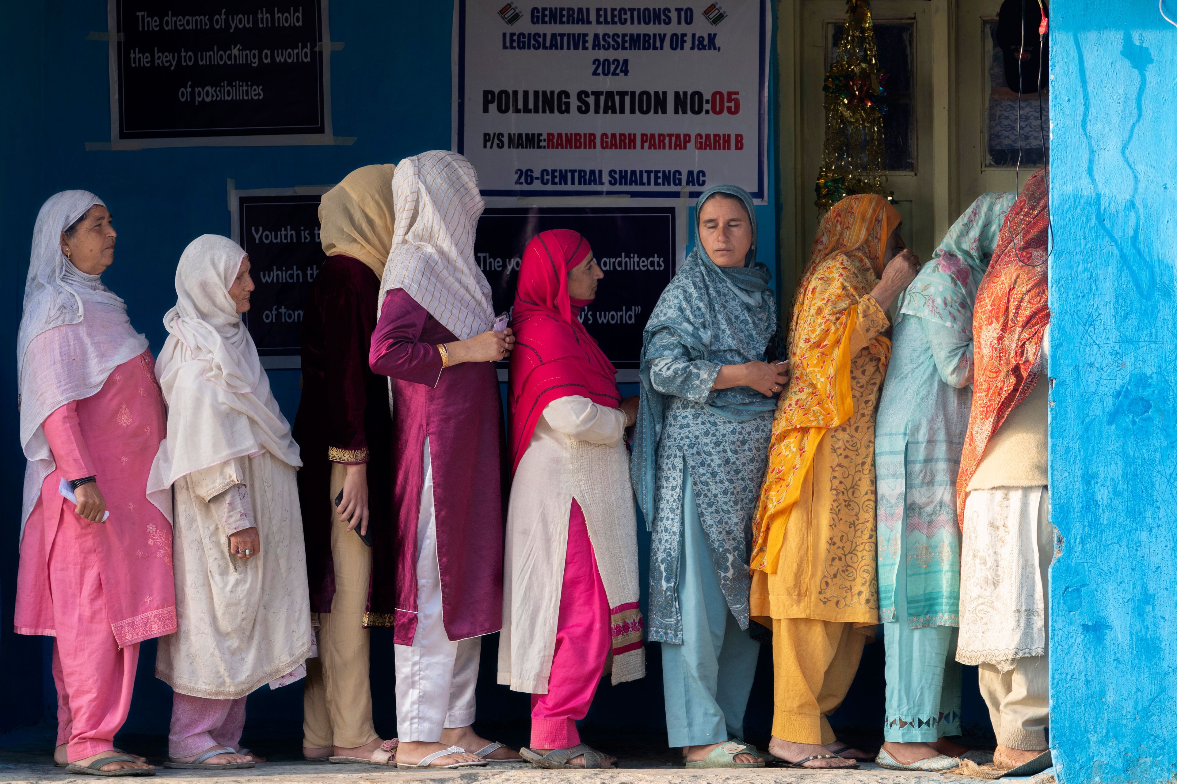 Kashmiri women queue up at a polling booth to cast their vote during the second phase of the assembly election in the outskirts of Srinagar, Indian controlled Kashmir, Wednesday, Sept. 25, 2024. (AP Photo/Dar Yasin)