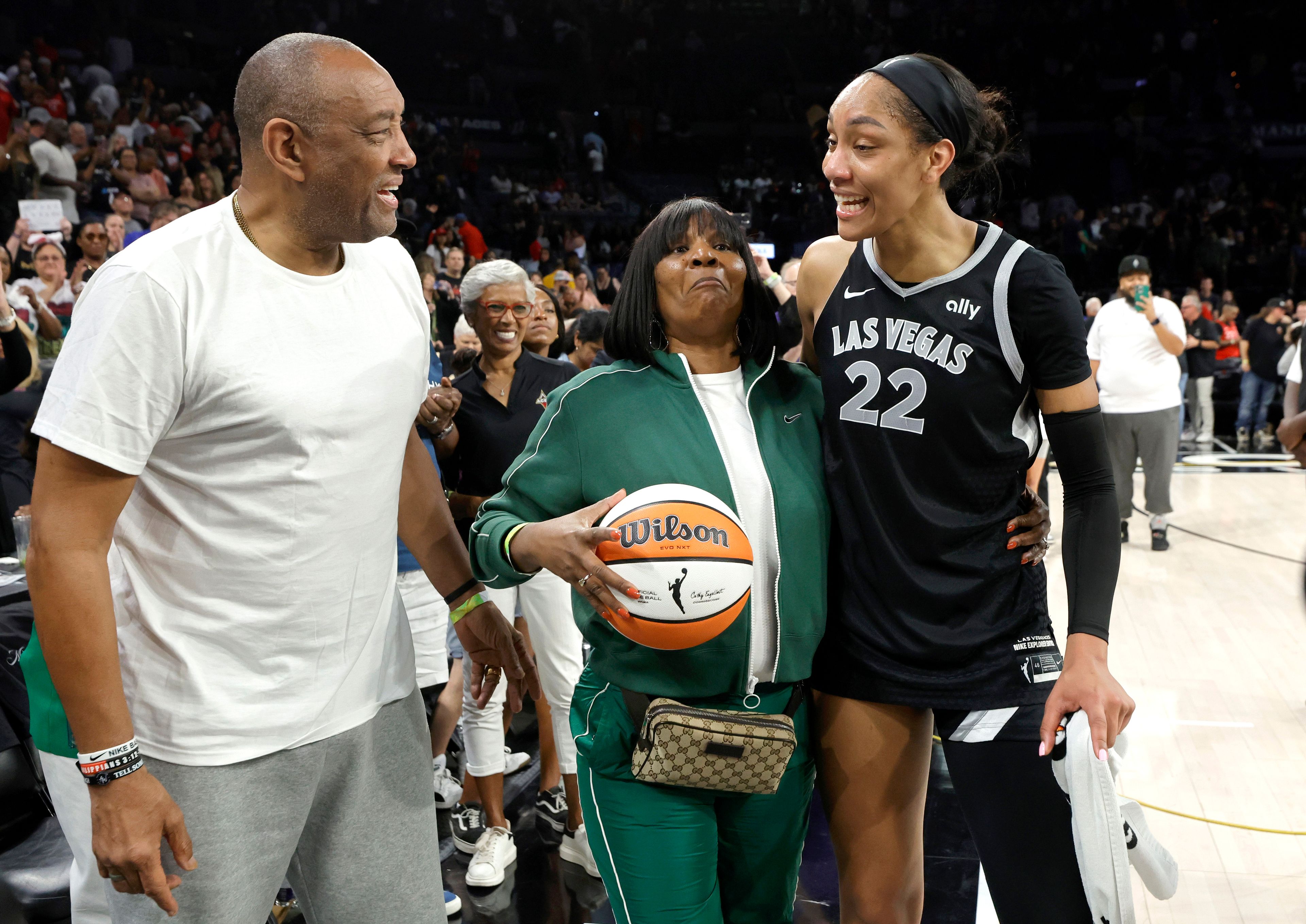 Las Vegas Aces center A'ja Wilson (22) celebrates with her parents Roscoe and Eva Wilson after an WNBA basketball game against the Connecticut Sun, Sunday, Sept. 15, 2024, in Las Vegas. (Steve Marcus/Las Vegas Sun via AP)