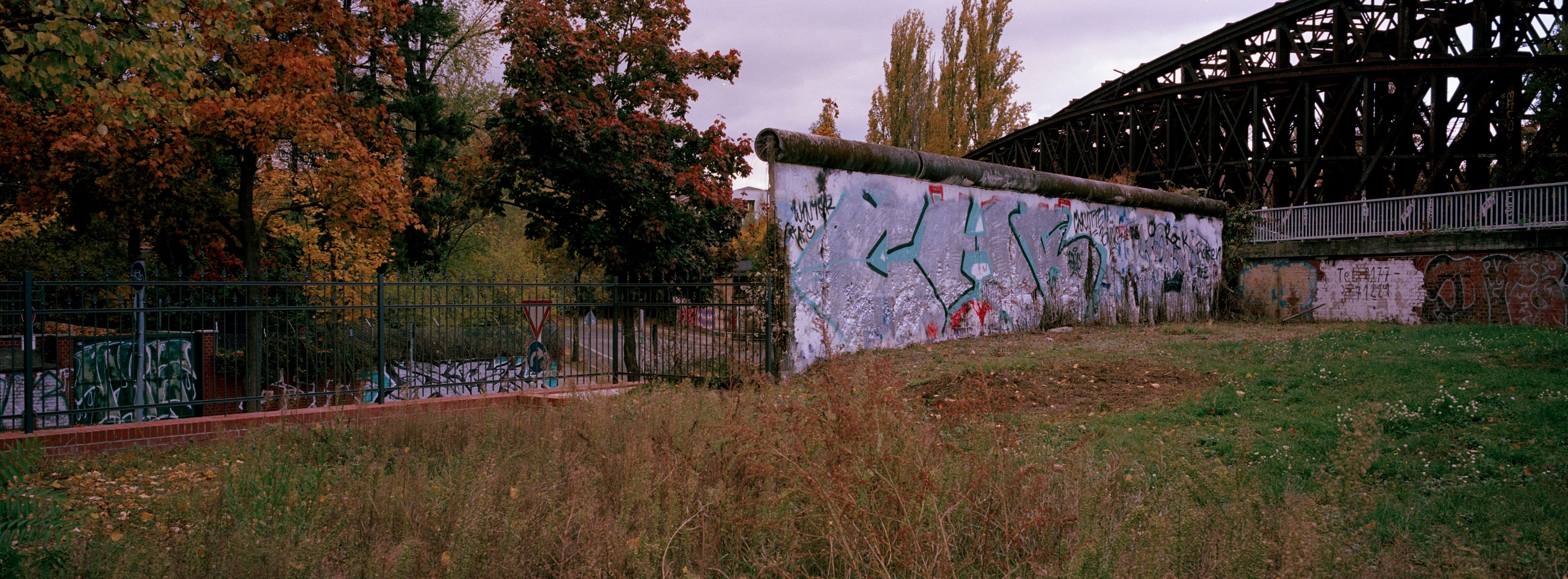 Graffiti-covered remains of the former Berlin Wall stand at a cemetery in central Berlin, Germany, Tuesday, Oct. 22, 2024. (AP Photo/Markus Schreiber)