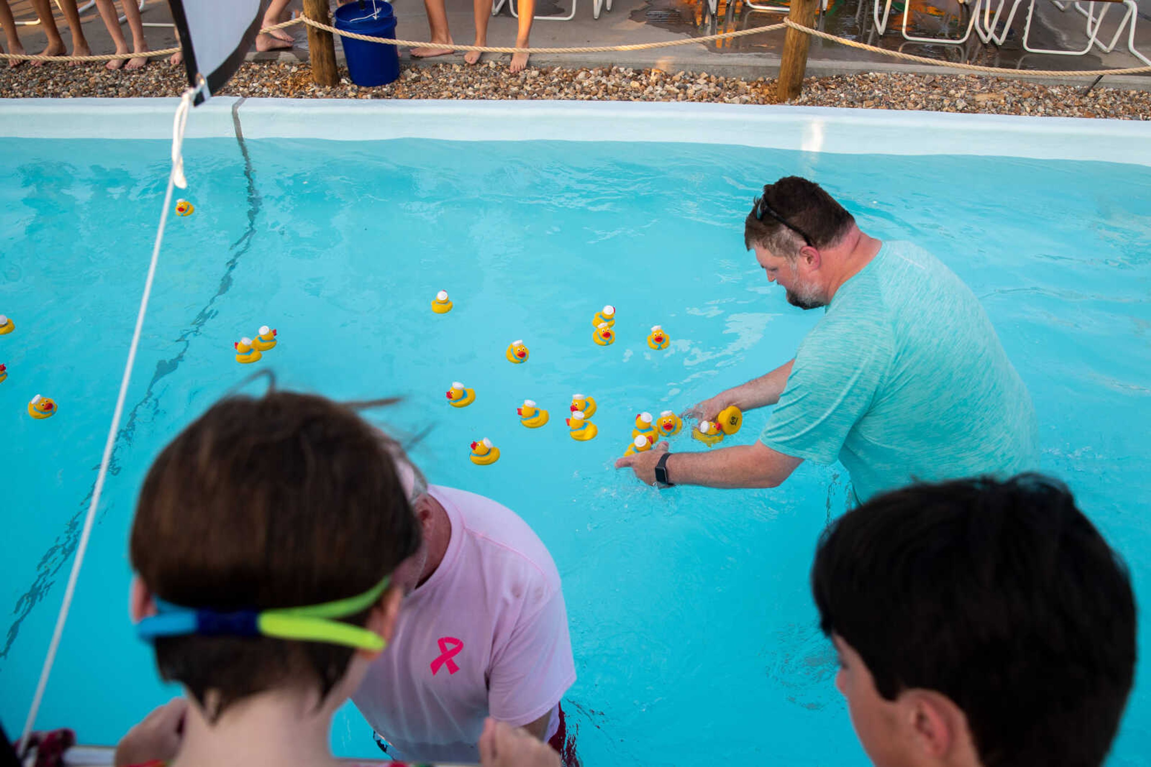 Chris McAuley, rotary treasurer, grabs the rubber ducks as they cross the finish line.