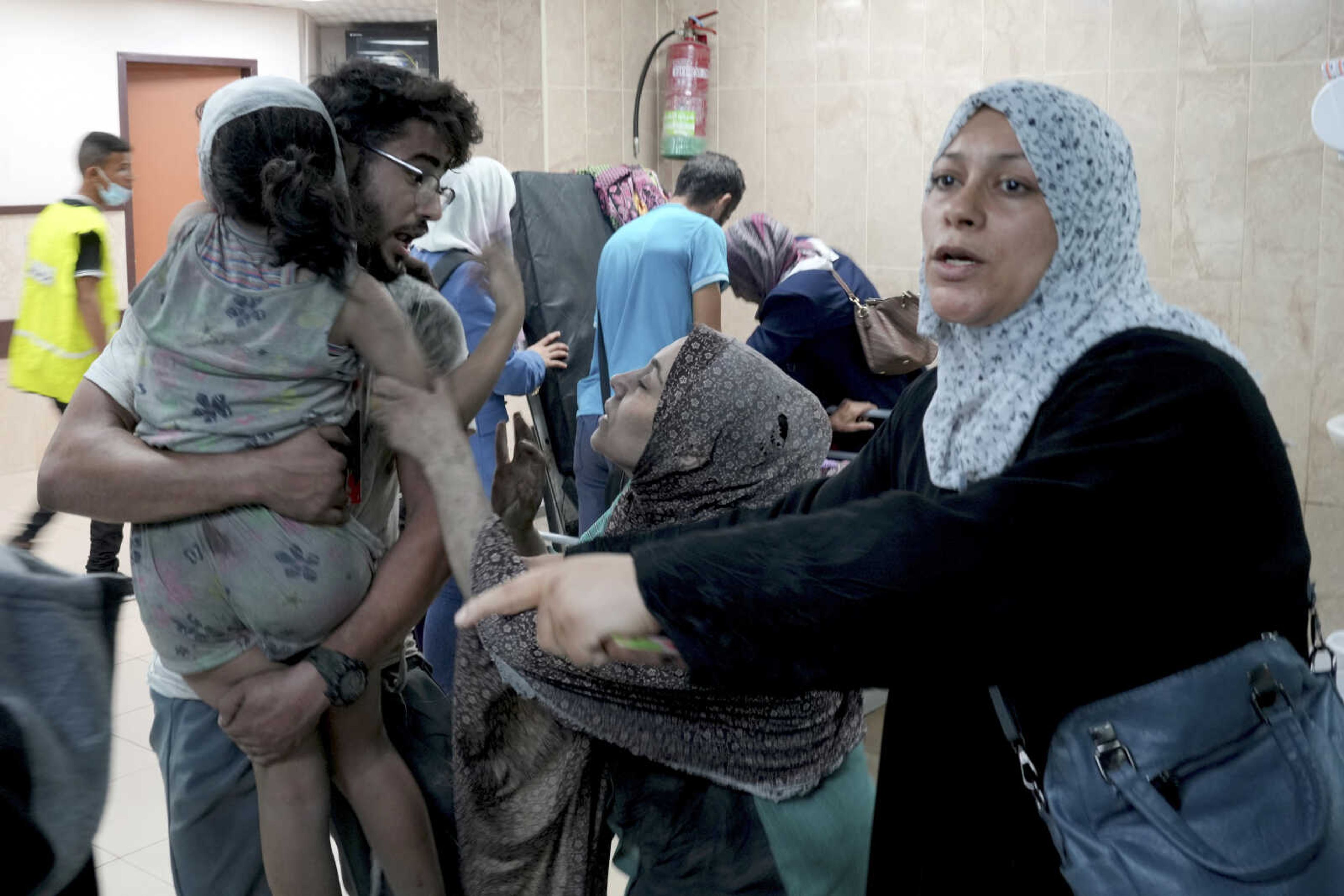 Palestinians bring a girl wounded in Israeli bombardment to a hospital Wednesday in Deir Al-Balah, south of the Gaza Strip.