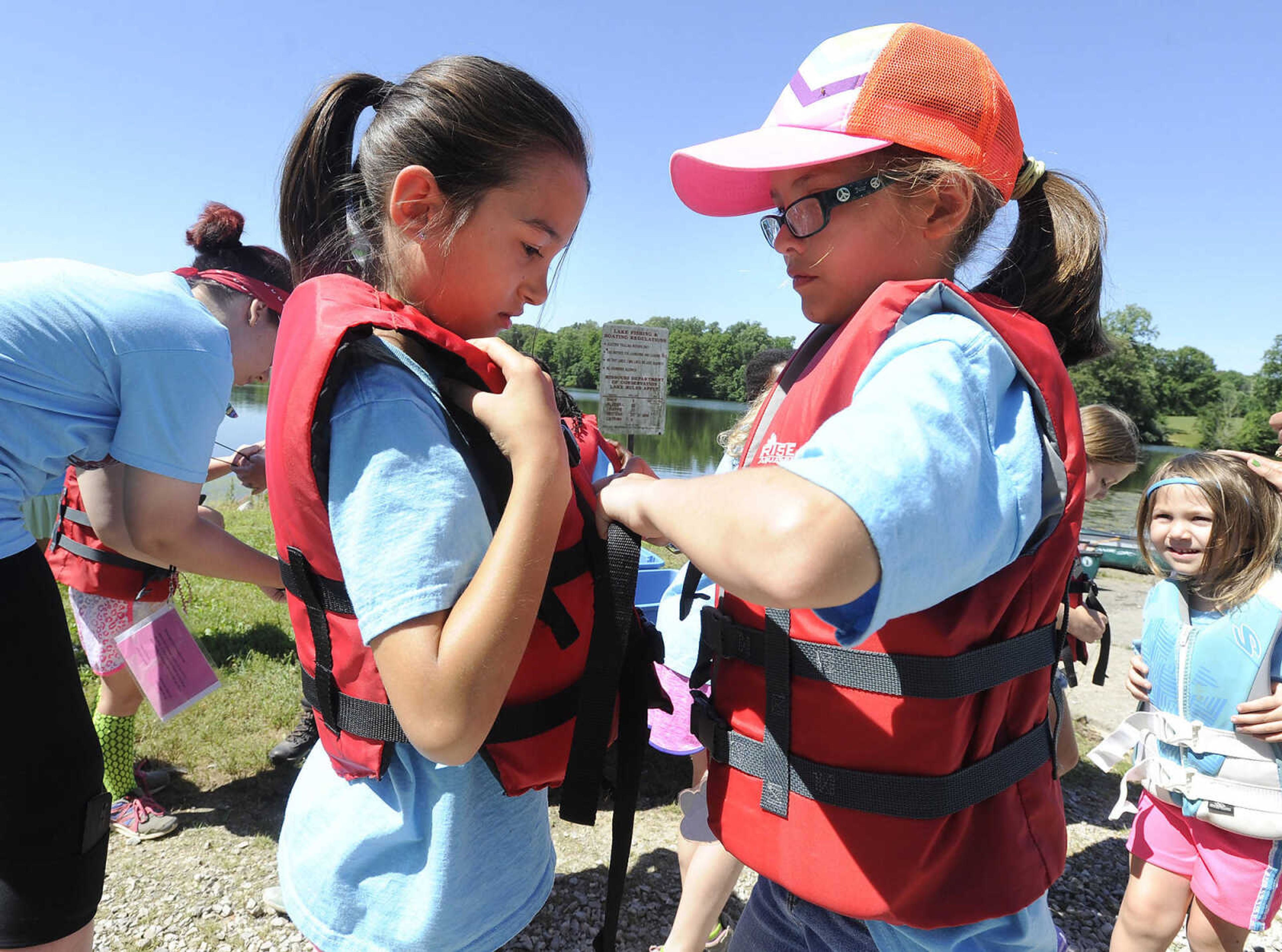 FRED LYNCH ~ flynch@semissourian.com
Brownie Girl Scouts Corinna Fisher, left, and Joslyn Wingo check their flotation vests before canoeing Thursday, June 8, 2017 during Girl Scout day camp at Elks Lake in Cape Girardeau.