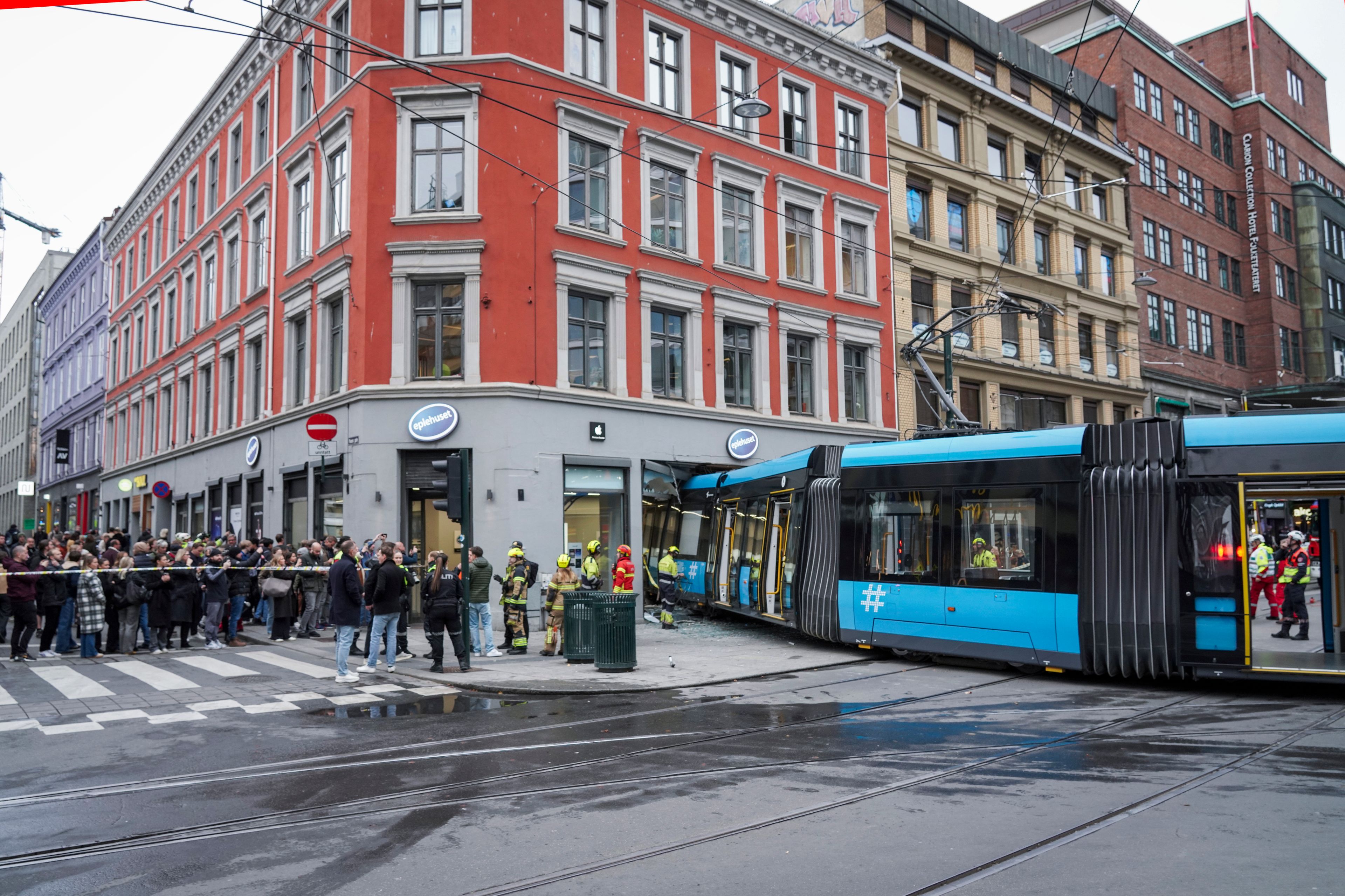 People and rescuers gather at the scene where a tram derailed and crashed into a building in downtown Oslo, Norway, Tuesday Oct. 29, 2024. (Terje Pedersen/NTB Scanpix via AP)