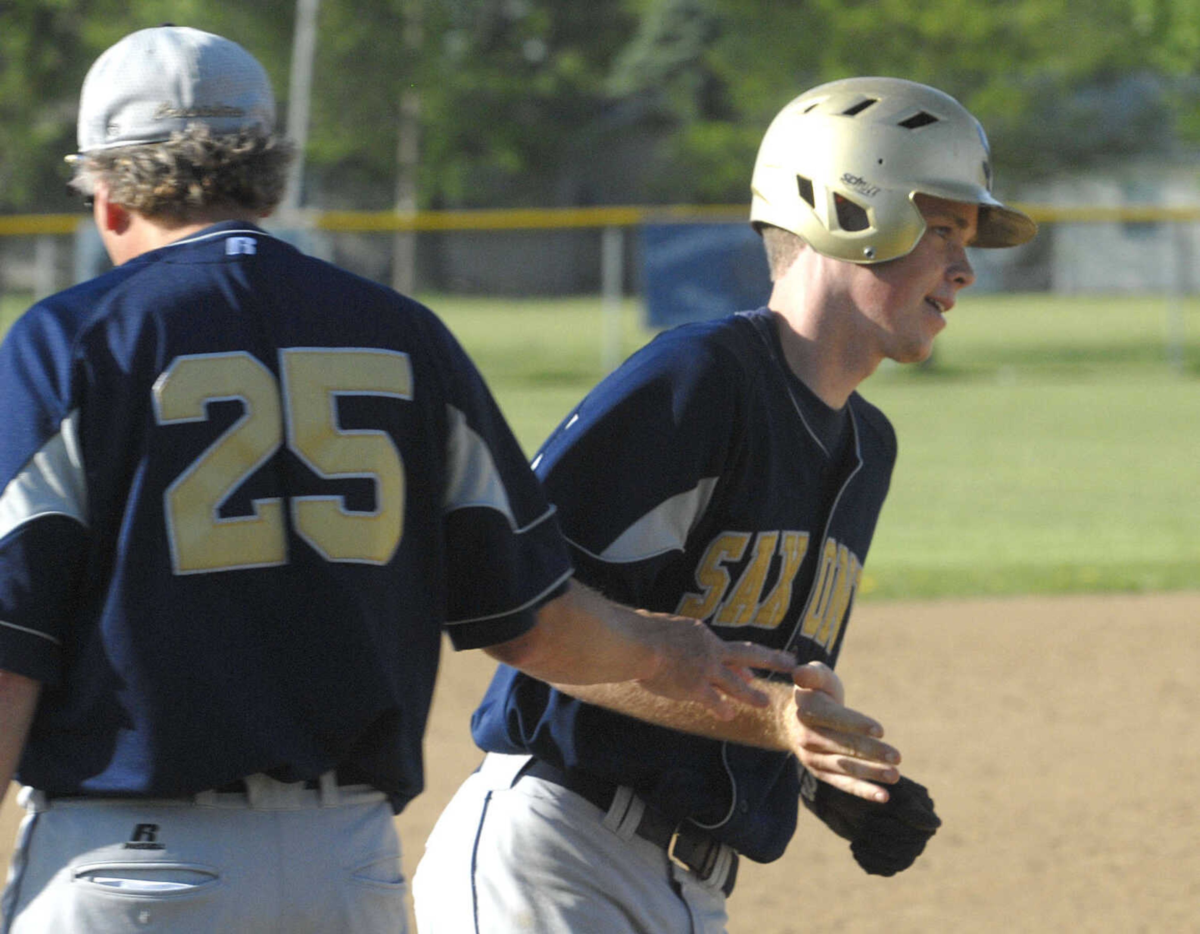 Saxony Lutheran's Garrett Fritsche passes third base coach Paul Sander after his three-run homer against Chaffee in the seventh inning Thursday at Chaffee.