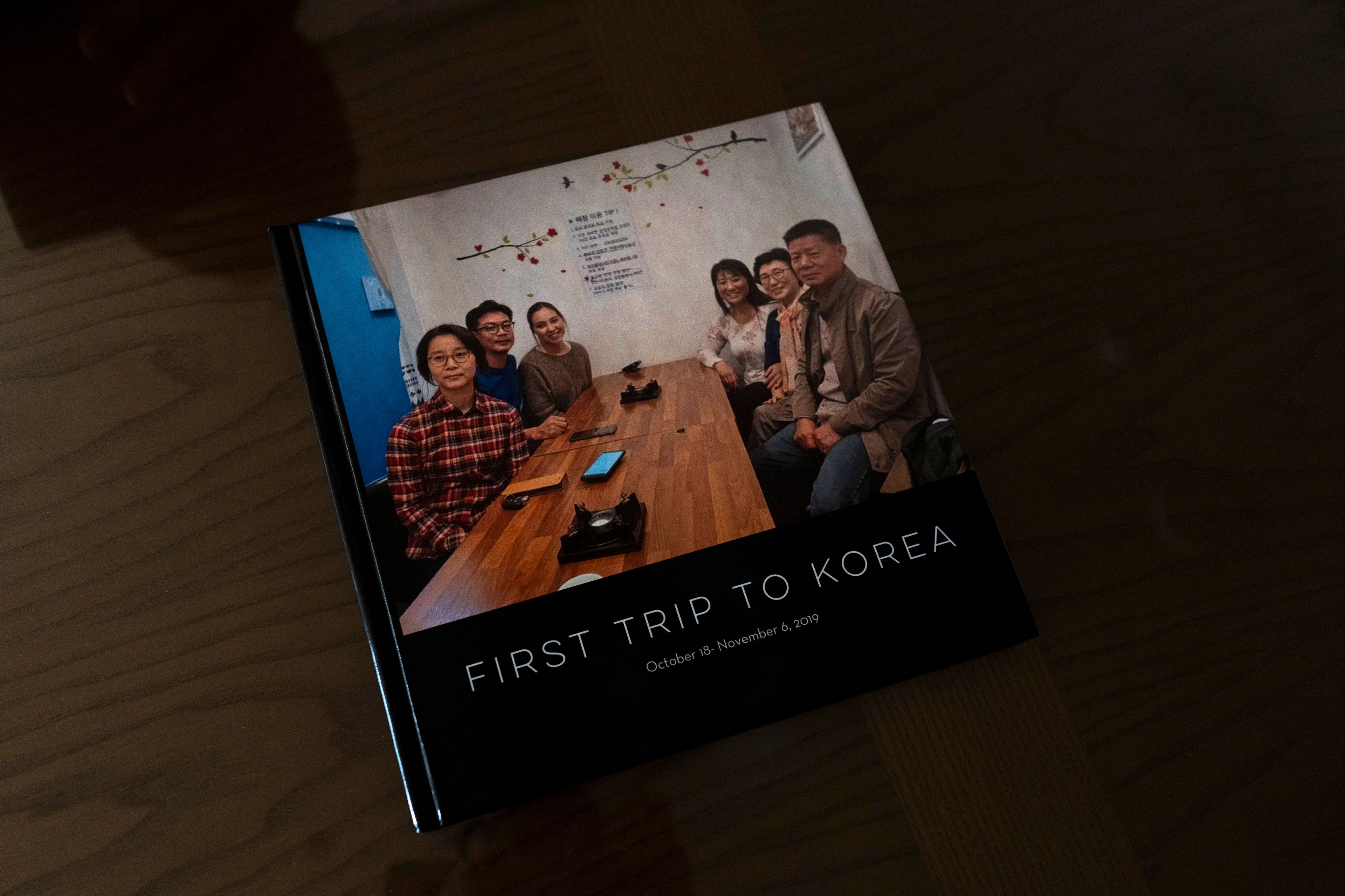 A photo book sits in the home of Han Tae-soon in Anyang, South Korea, on Saturday, June 1, 2024. Han's daughter, Laurie Bender, third from right sitting next to Han, made her the album to celebrate their reunion. Bender was approached by a strange woman while playing in the front yard in Korea in 1975. She remembers the woman saying that Bender's family didn't want her anymore because her mother had another baby. She went with the woman and felt so sad she thought she might die. (AP Photo/Jae C. Hong)