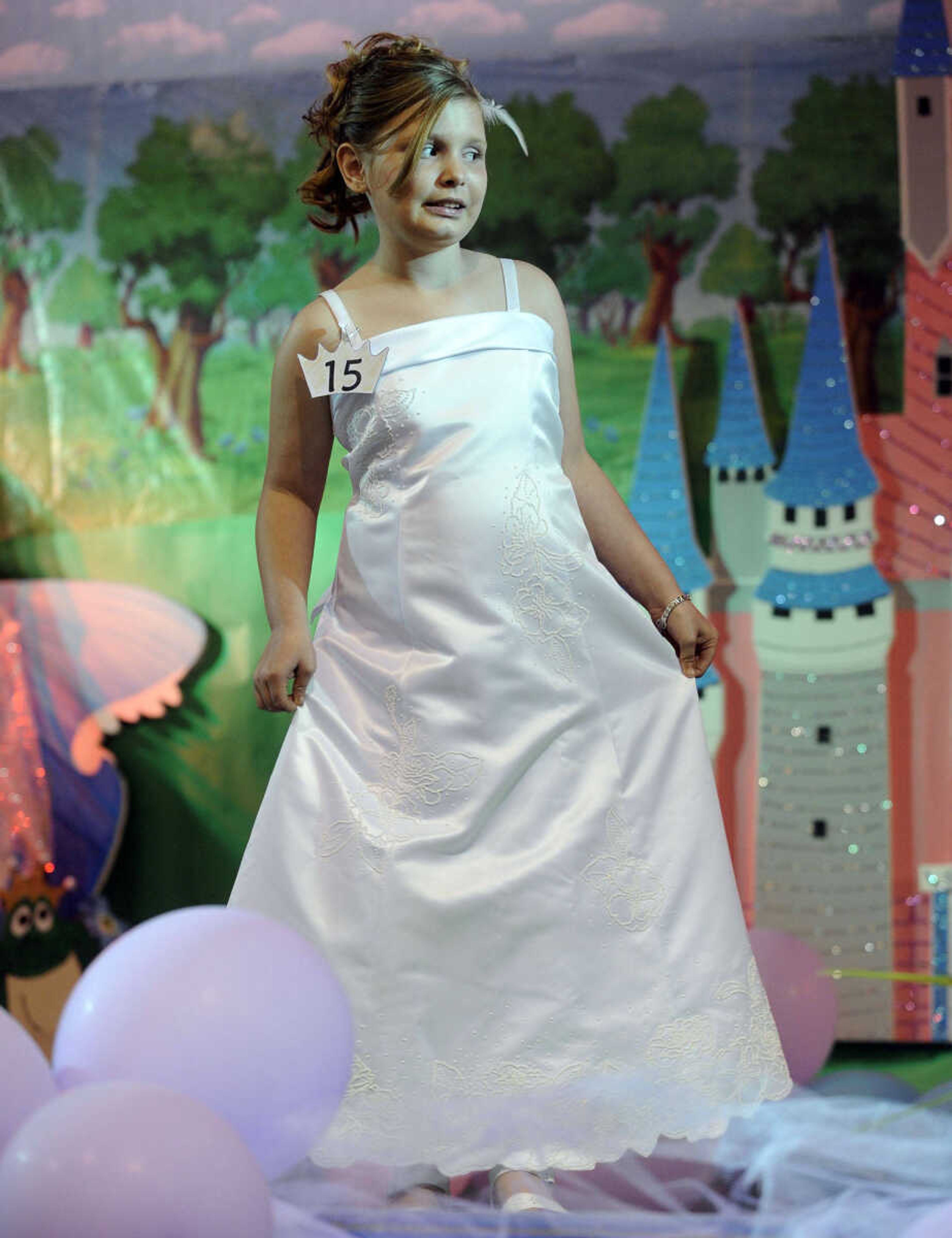 KayLee Williams stands in the spotlight in the 5-9 age division of the S. E. Missouri Angels Pageant on Saturday, April 26, 2014 at Scott City High School.