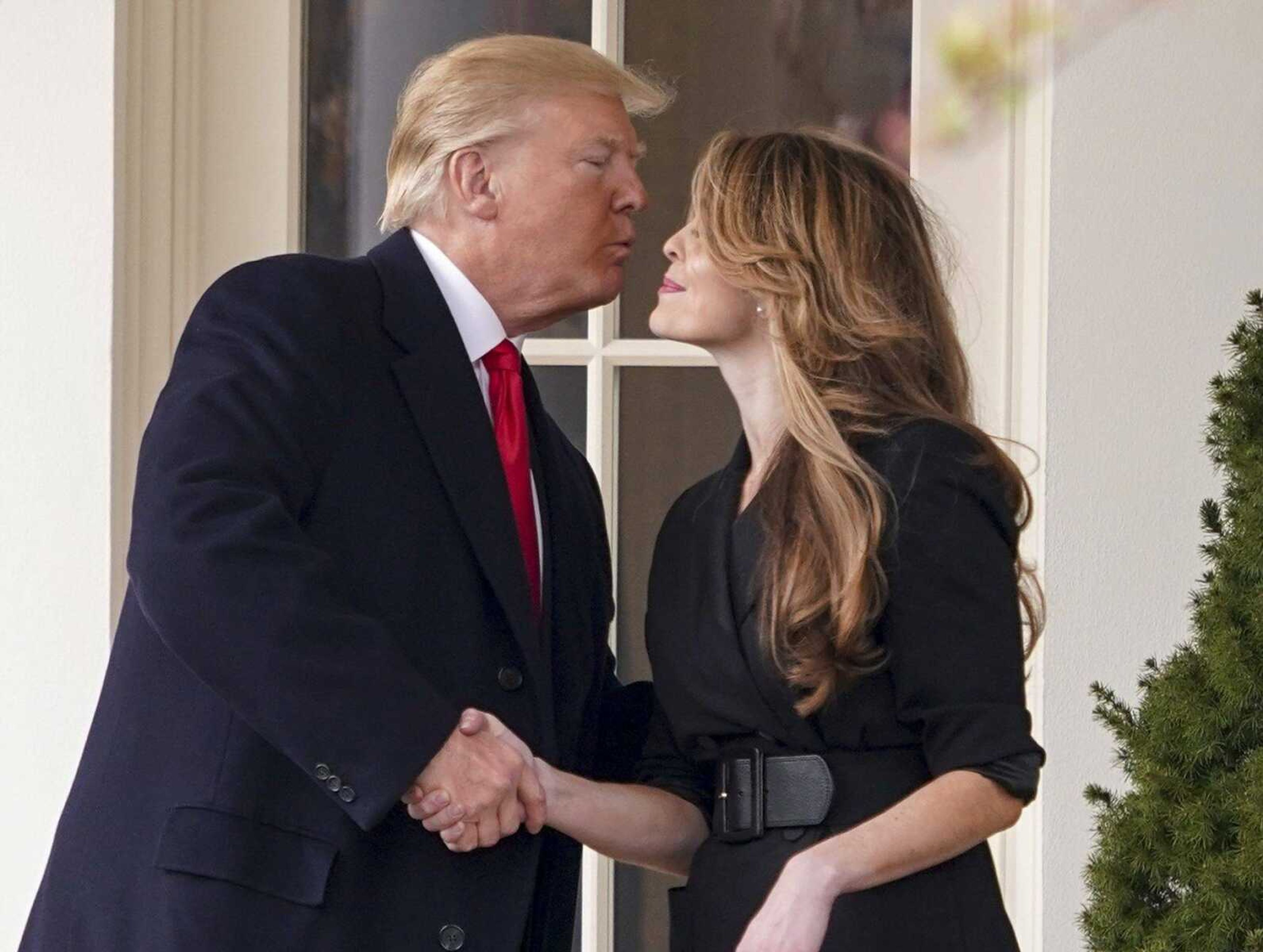 President Donald Trump kisses White House communications director Hope Hicks on her last day in the position. Hicks stepped down Thursday.