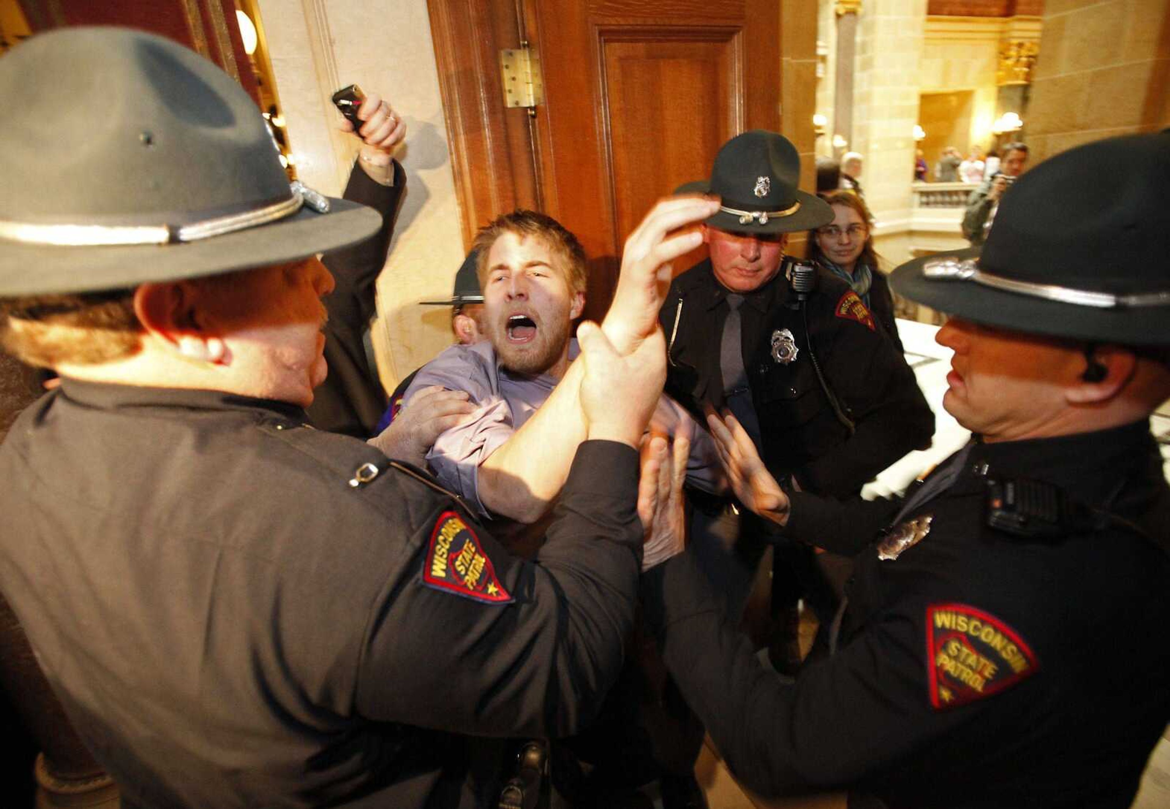 Wisconsin State Patrol officers pull a protester out of the state Assembly antechamber at the state Capitol on Thursday in Madison, Wis. (M.P. King ~ Wisconsin State Journal)