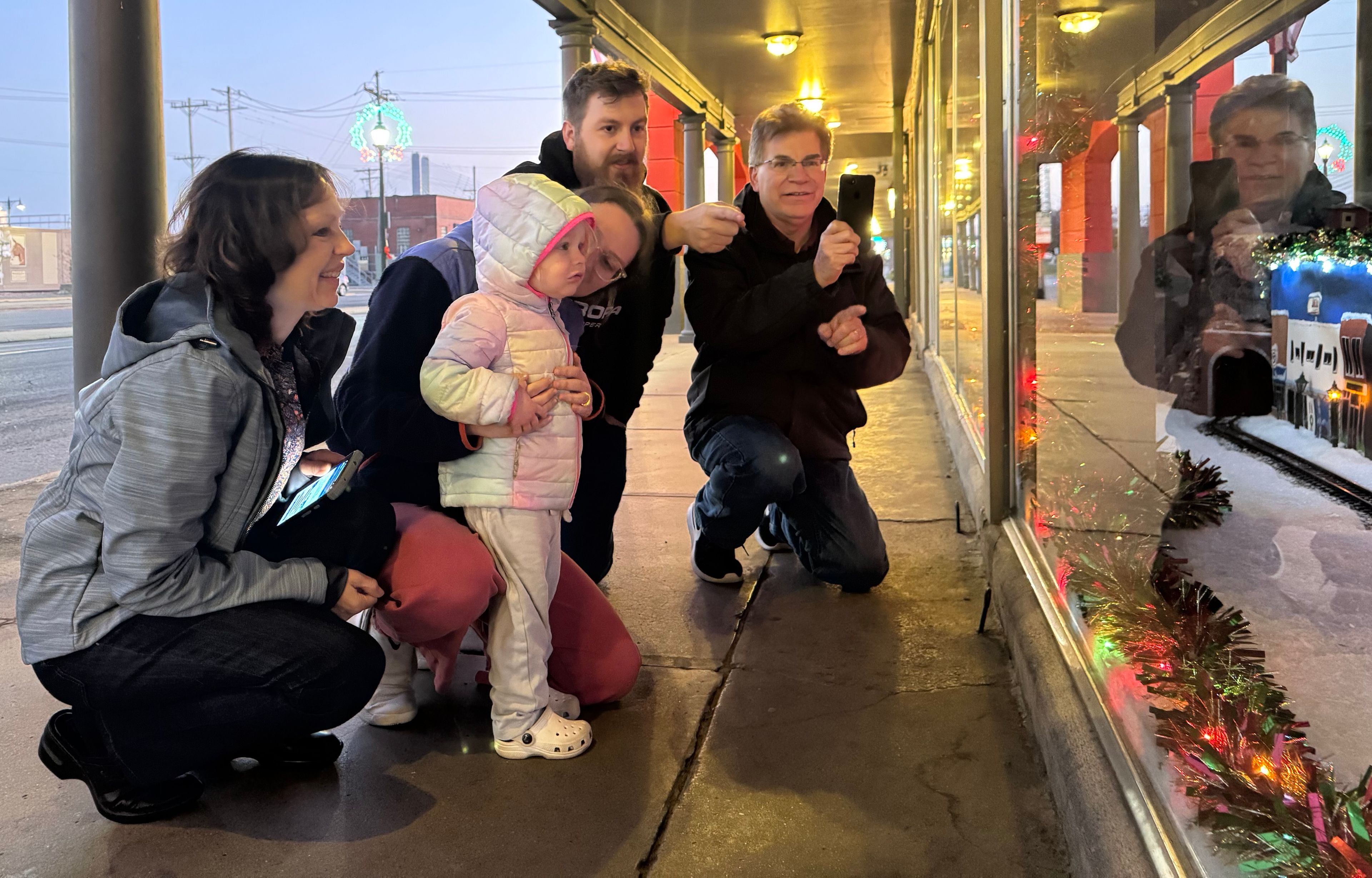 Members of the Herbst family — from left, Patsy, Angela, Chris and Don — introduce Lily to the Thanksgiving tradition of checking out the Hutson's Big Sandy Superstore window Christmas display Thursday, Nov. 28, in Cape Girardeau.